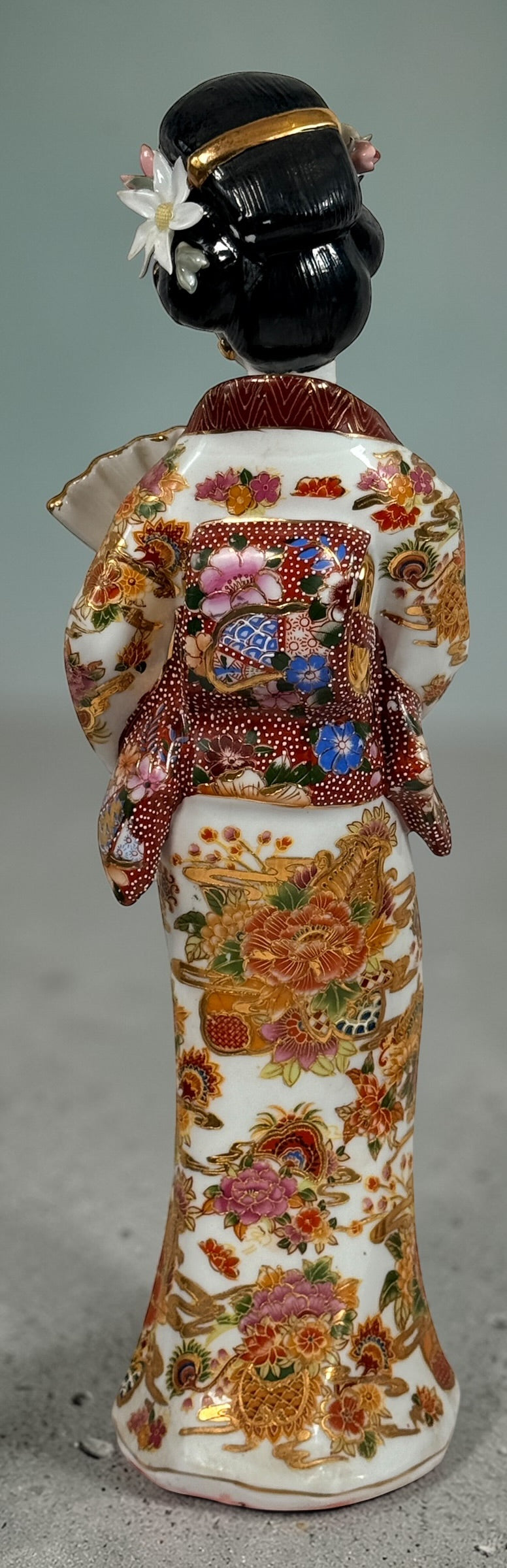 Vintage Japanese porcelain geisha figurine with hand-painted florals and raised gilt moriage detail. Elegant mid-century decorative display piece