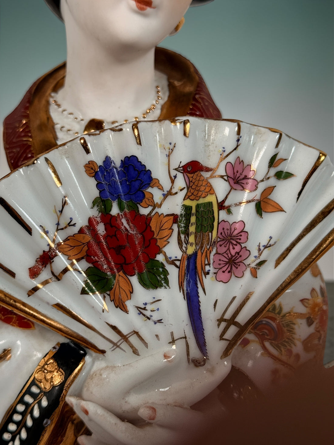Vintage Japanese porcelain geisha figurine with hand-painted florals and raised gilt moriage detail. Elegant mid-century decorative display piece