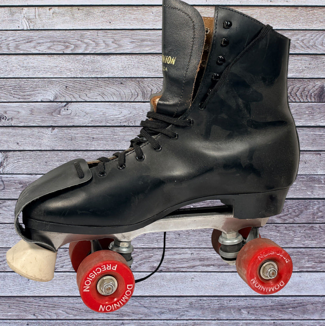 Vintage Dominion Canada leather roller skates, black quad setup with original Dominion Precision wheels. Classic rink style, estimated men’s size 10.