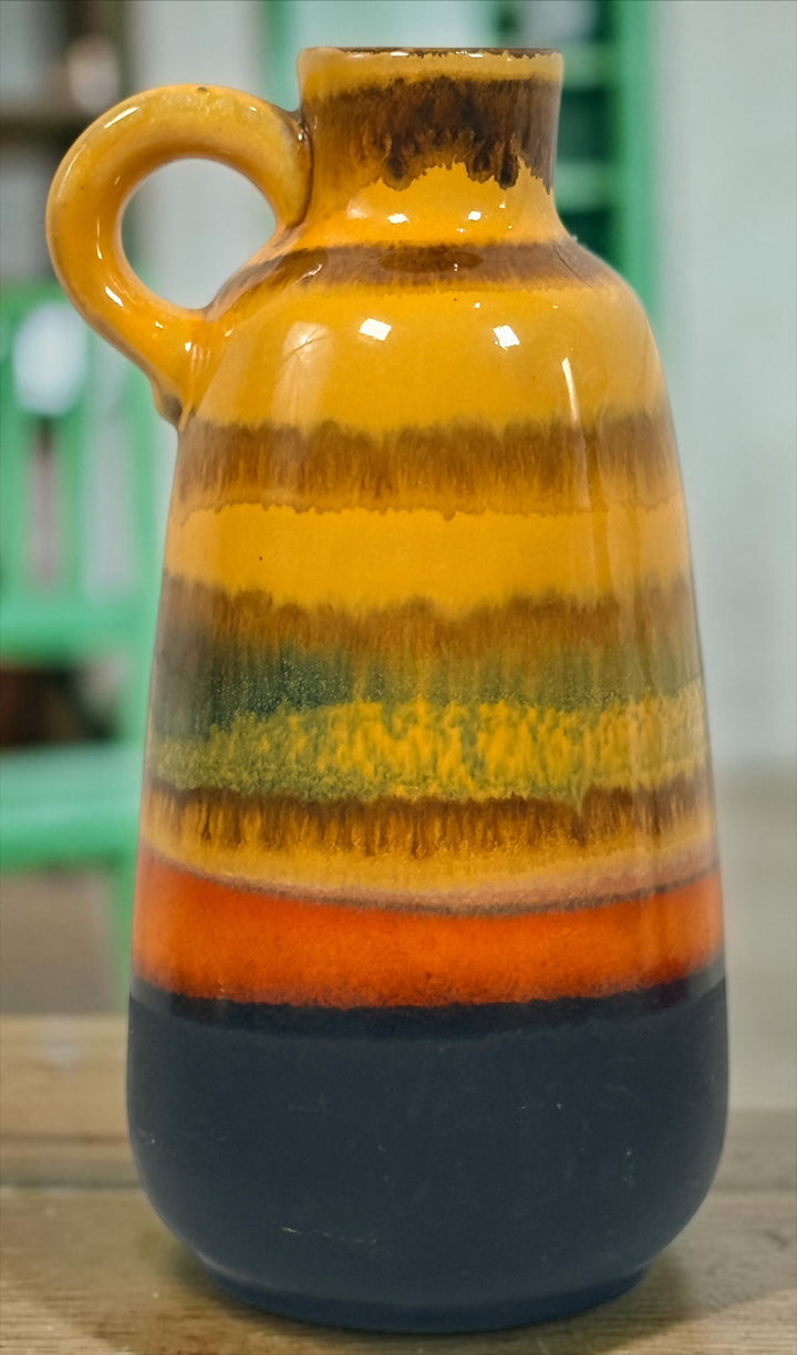 Vintage 1970s West German pottery vase marked 153L-20 with loop handle and colourful mustard, orange, green and brown striped glaze.
