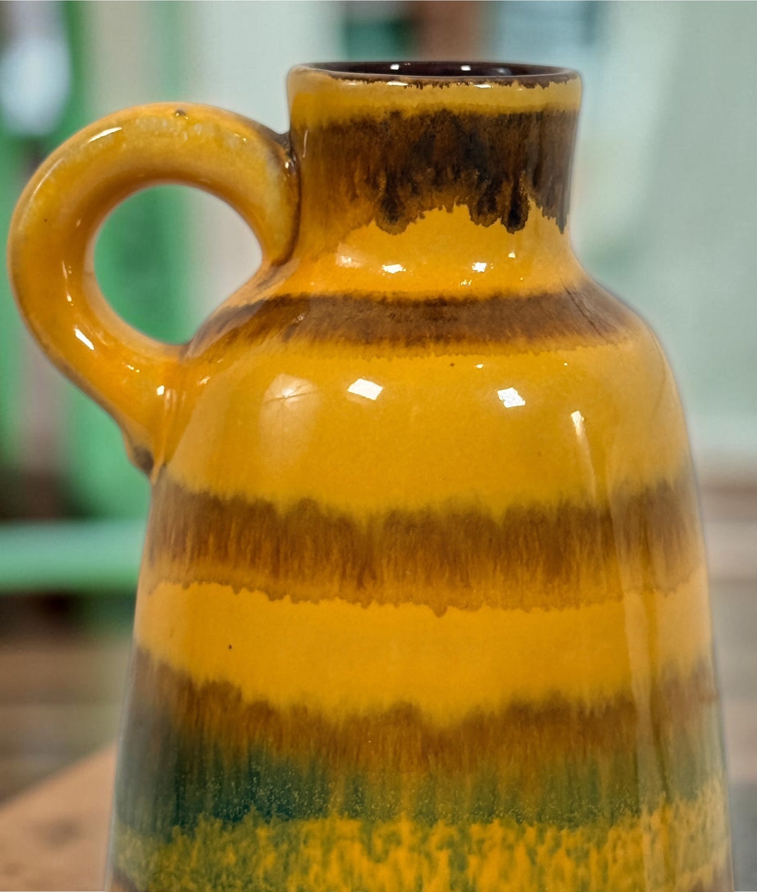 Vintage 1970s West German pottery vase marked 153L-20 with loop handle and colourful mustard, orange, green and brown striped glaze.
