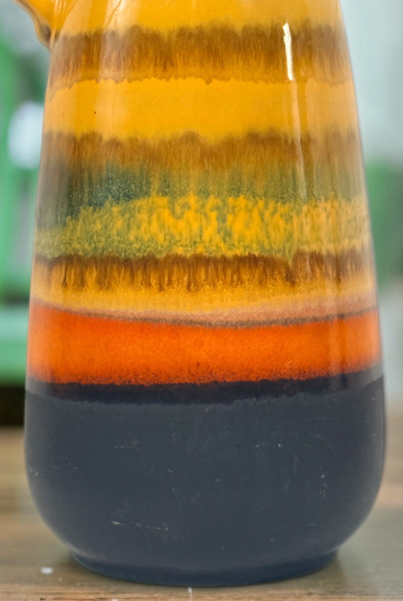 Vintage 1970s West German pottery vase marked 153L-20 with loop handle and colourful mustard, orange, green and brown striped glaze.