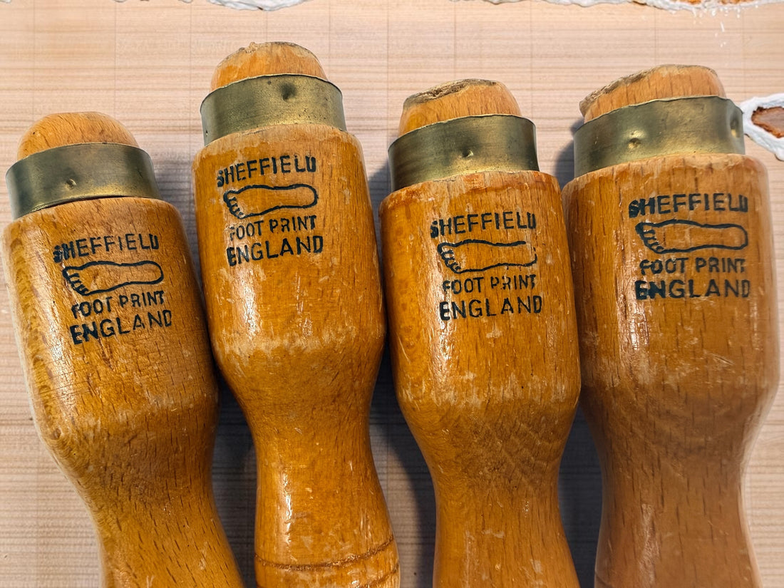 Vintage Footprint Sheffield England 4-piece woodworking chisel set with steel blades and hardwood handles. Classic British-made workshop tools.