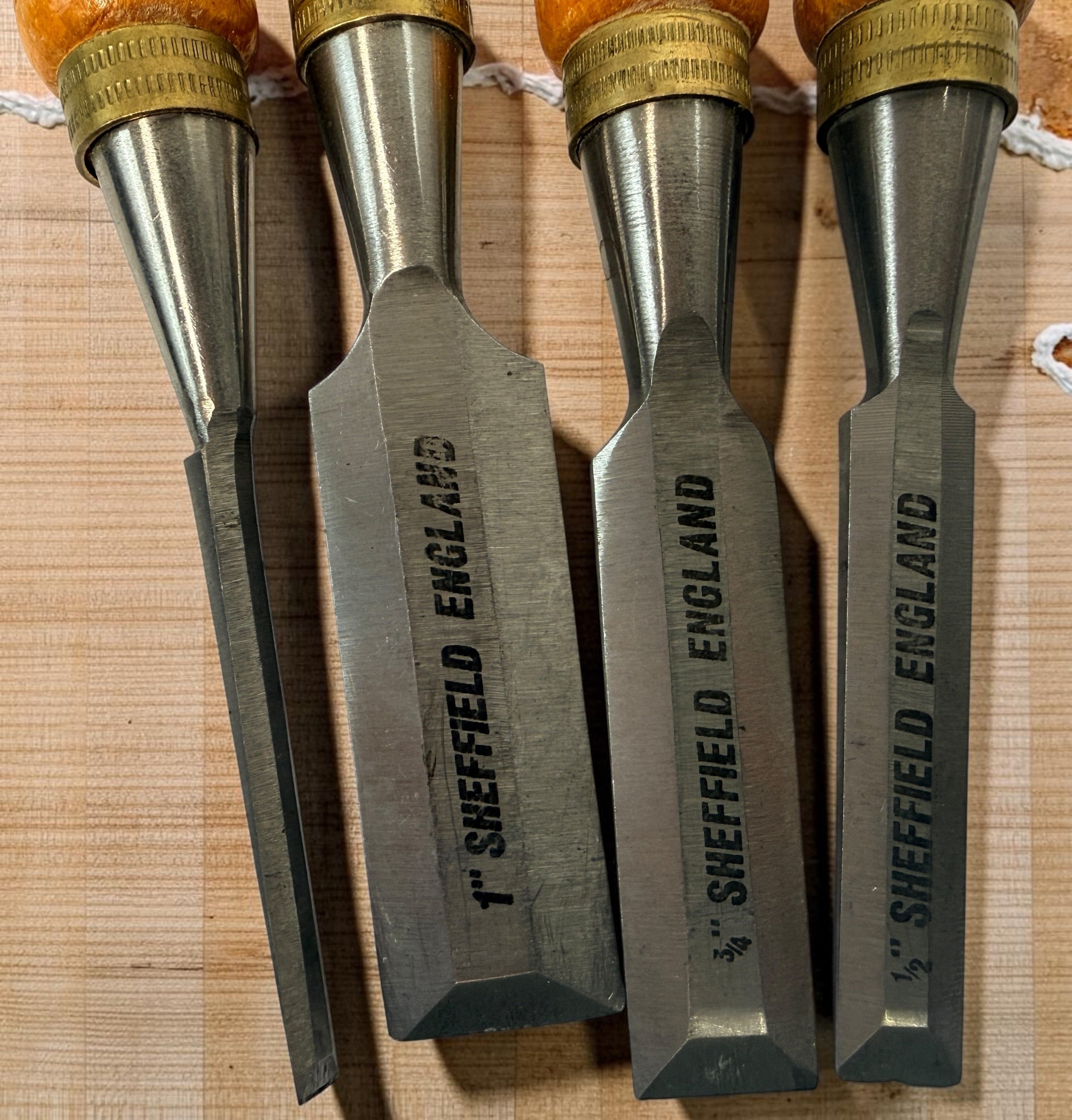 Vintage Footprint Sheffield England 4-piece woodworking chisel set with steel blades and hardwood handles. Classic British-made workshop tools.