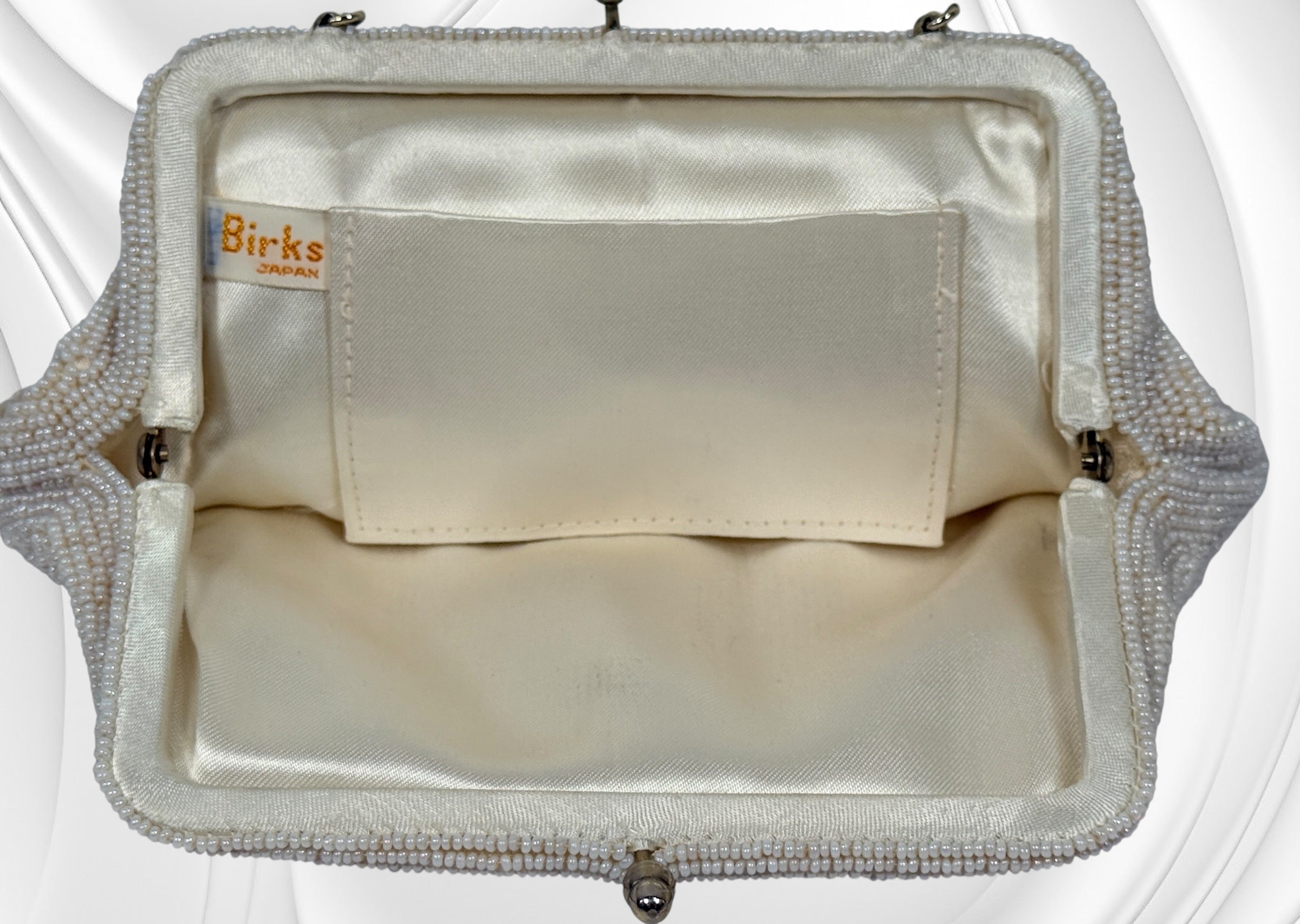 Vintage Birks white beaded evening clutch made in Japan with gold frame and chain strap. Elegant bridal or formal handbag in very good condition.