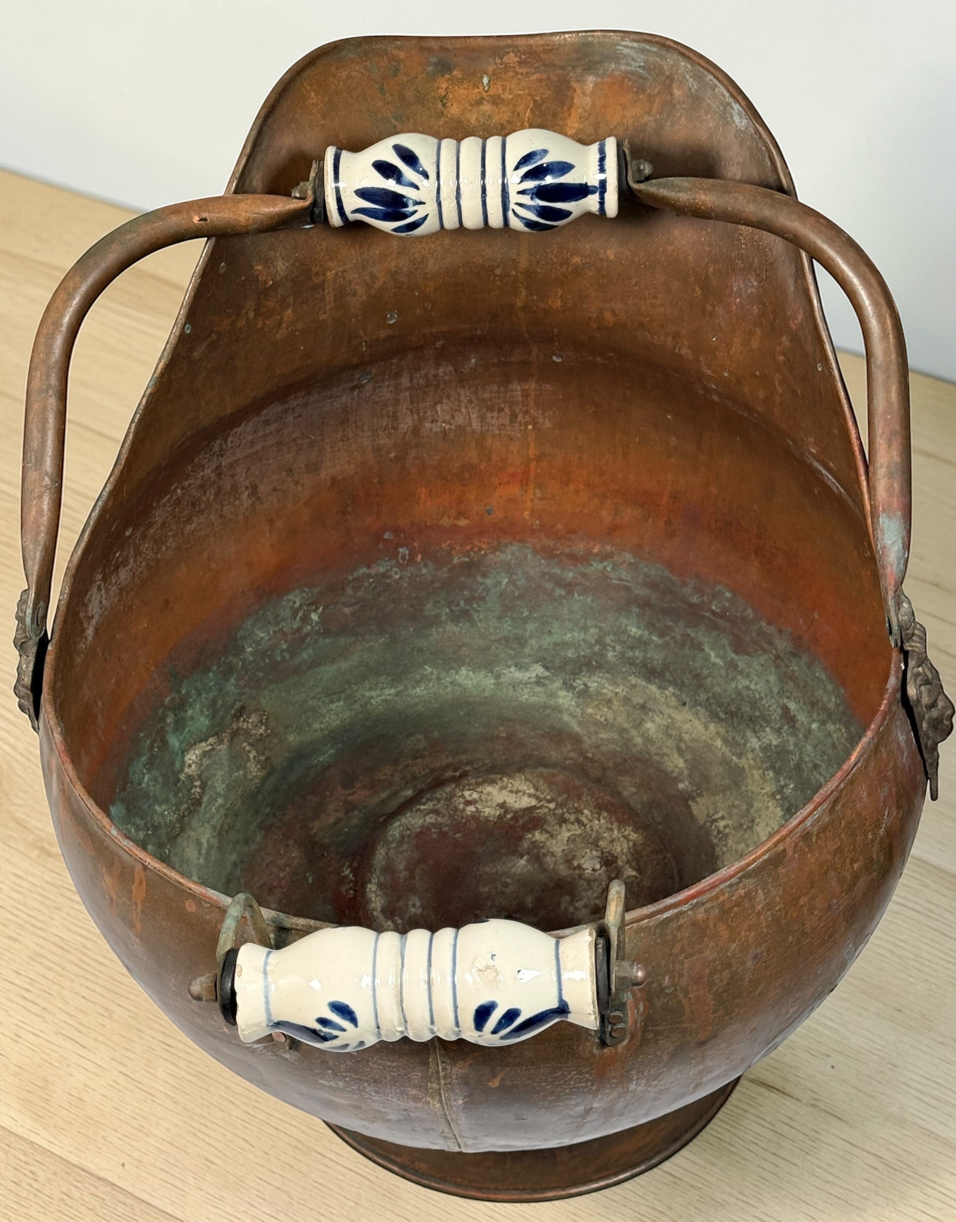 Vintage copper coal scuttle with lion head handles and ceramic grips. Classic fireplace log bucket with rich patina, perfect for rustic or traditional décor. 🔥