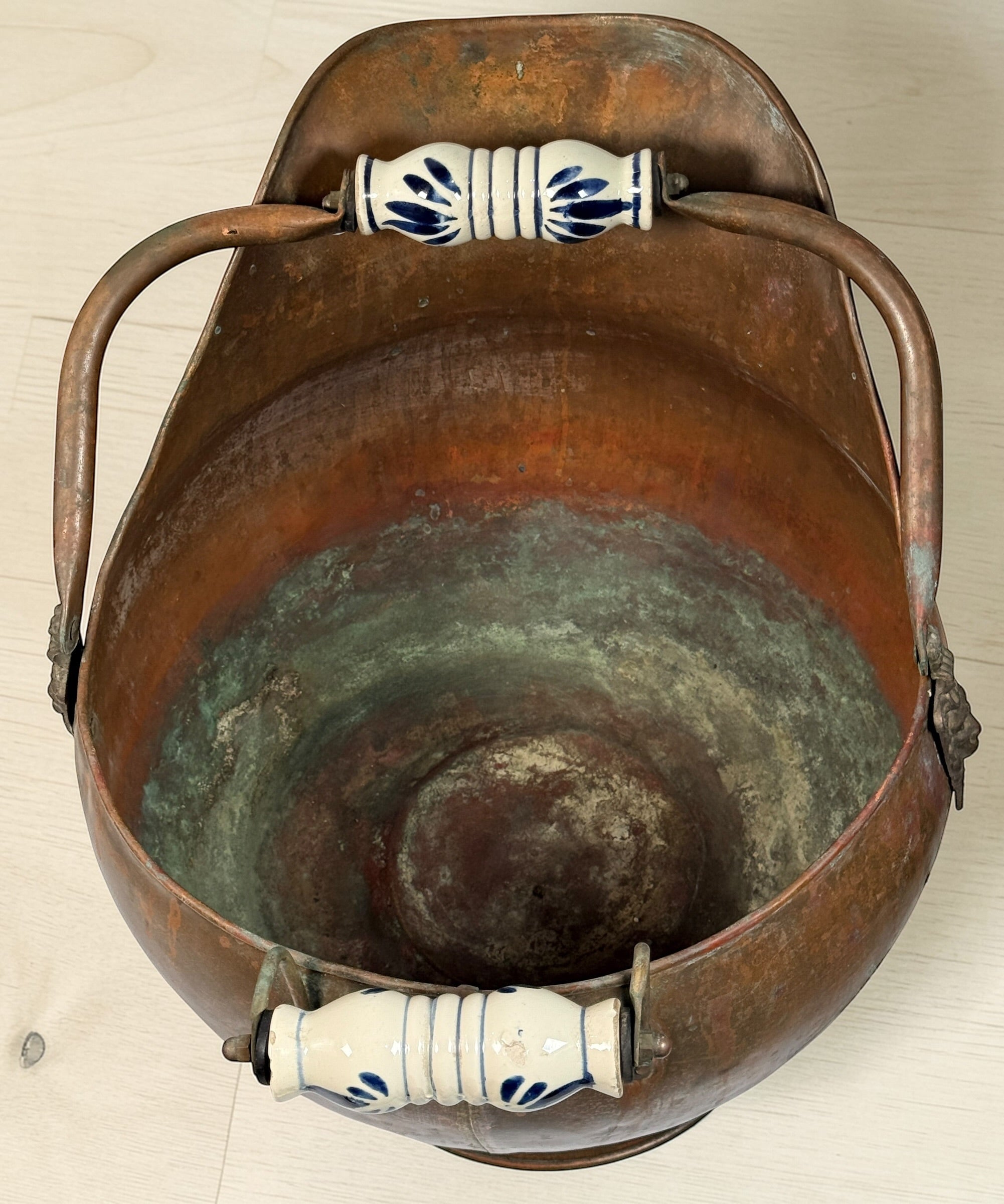 Vintage copper coal scuttle with lion head handles and ceramic grips. Classic fireplace log bucket with rich patina, perfect for rustic or traditional décor. 🔥