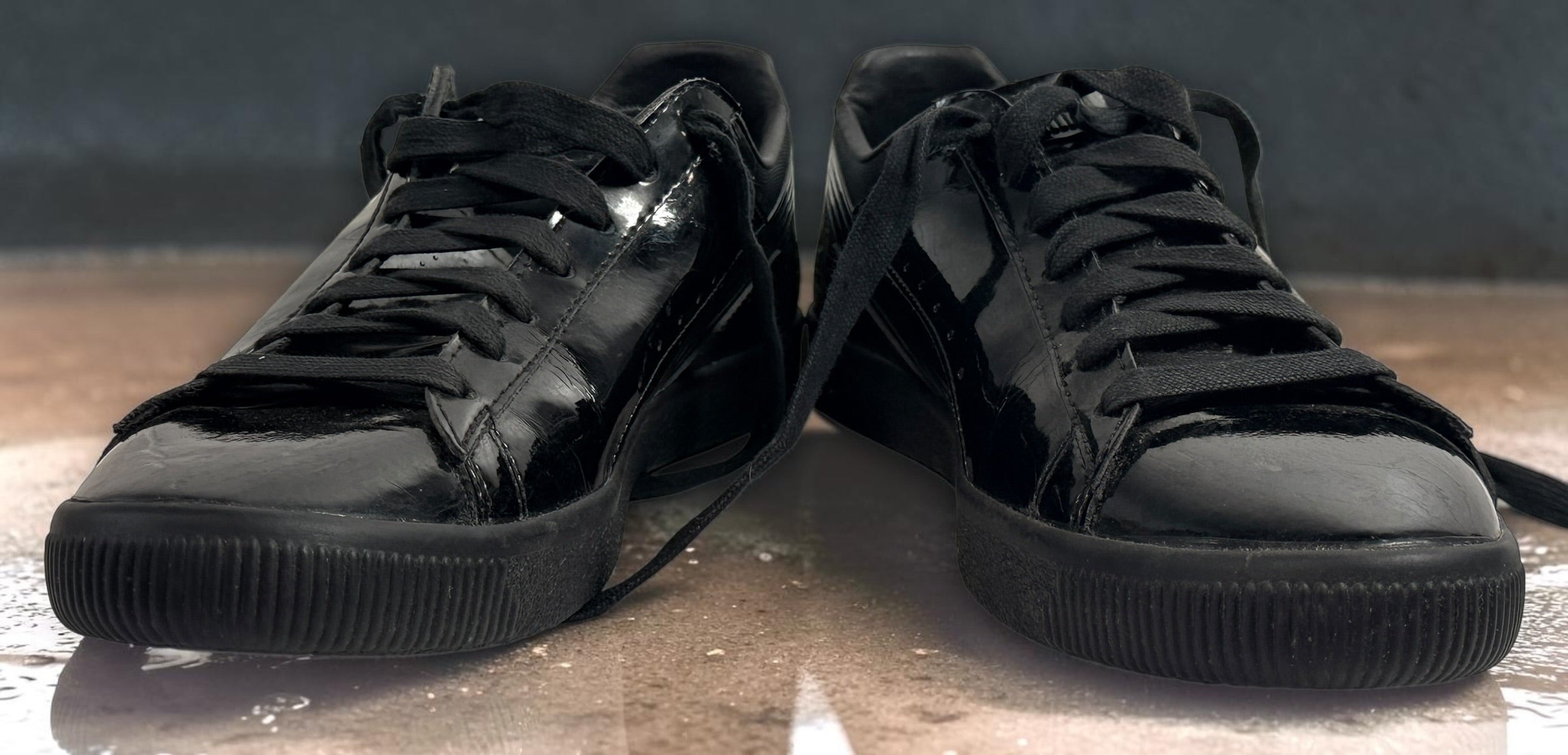 PUMA Clyde black patent-style men’s sneakers, US 10 / EU 43, featuring gold Clyde branding, tonal Formstrip and classic low-top styling.