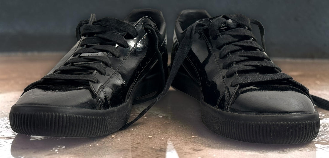 PUMA Clyde black patent-style men’s sneakers, US 10 / EU 43, featuring gold Clyde branding, tonal Formstrip and classic low-top styling.