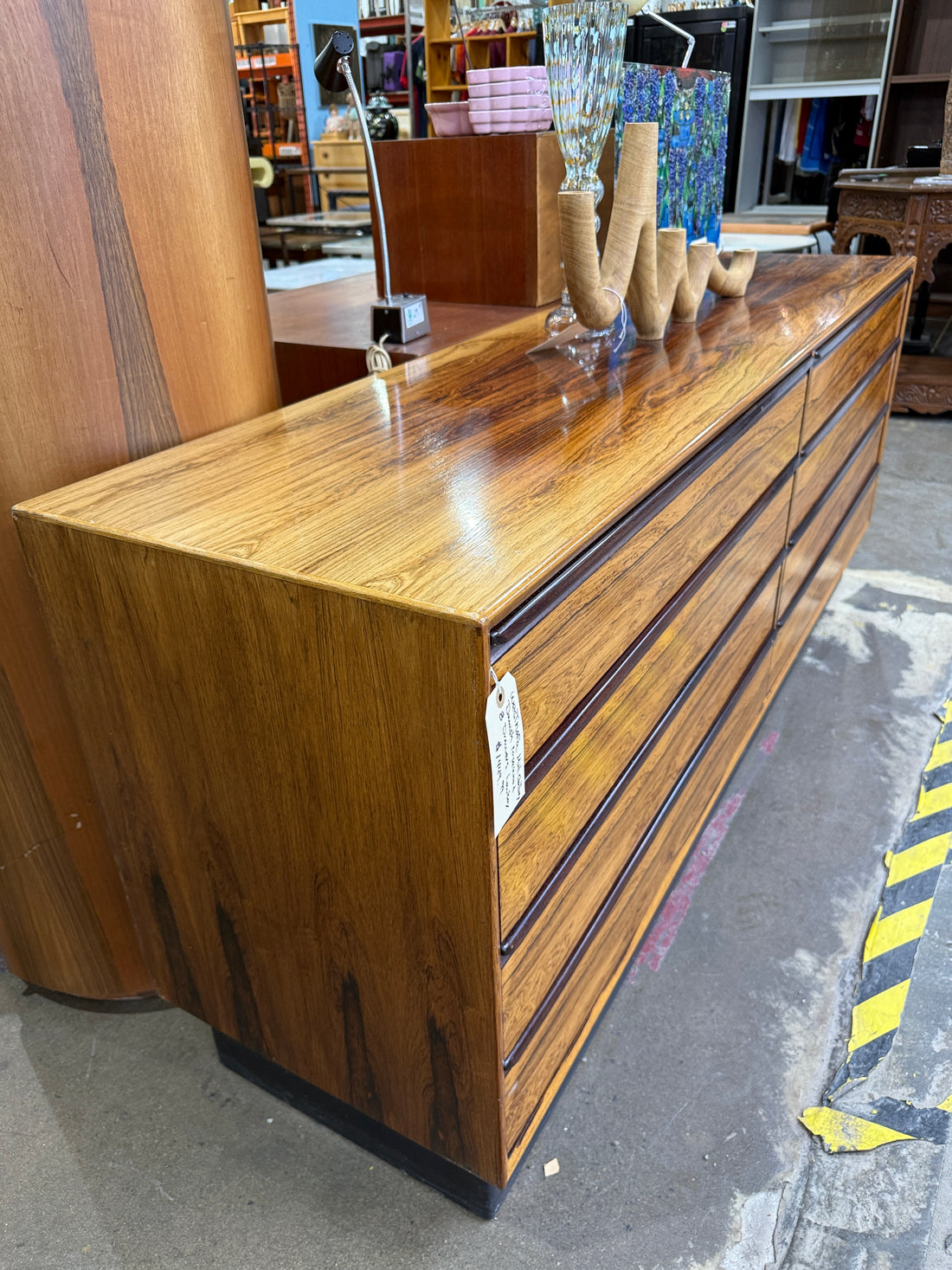 Vintage MCM rosewood lowboy dresser with 8 drawers and Danish modern styling. Large mid-century storage piece with stunning figured grain and clean lines.