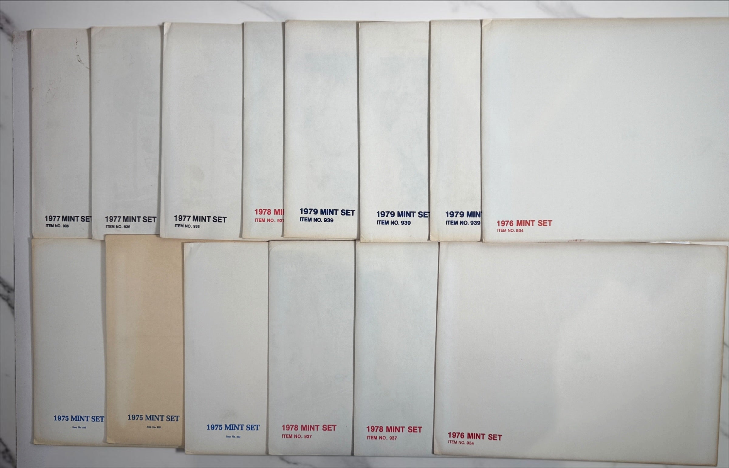 Vintage lot of 14 USPS Mint Sets of Commemorative Stamps from 1975–1979 with original stamps and presentation materials. Collectible U.S. postal history.