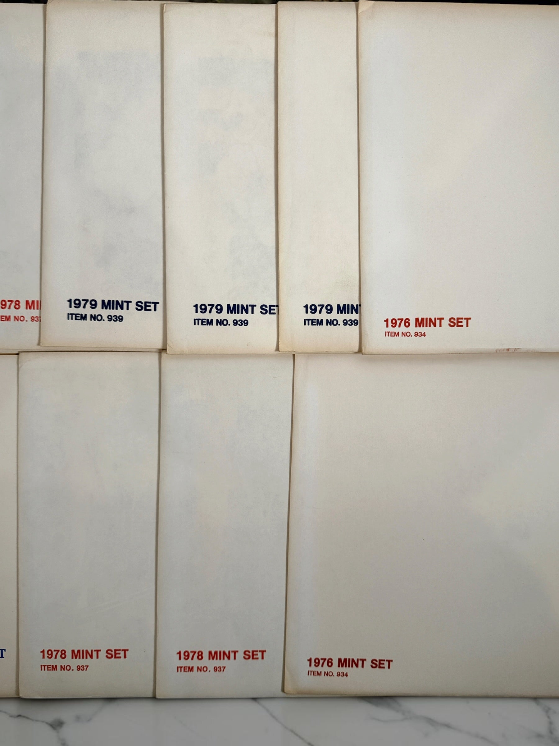 Vintage lot of 14 USPS Mint Sets of Commemorative Stamps from 1975–1979 with original stamps and presentation materials. Collectible U.S. postal history.