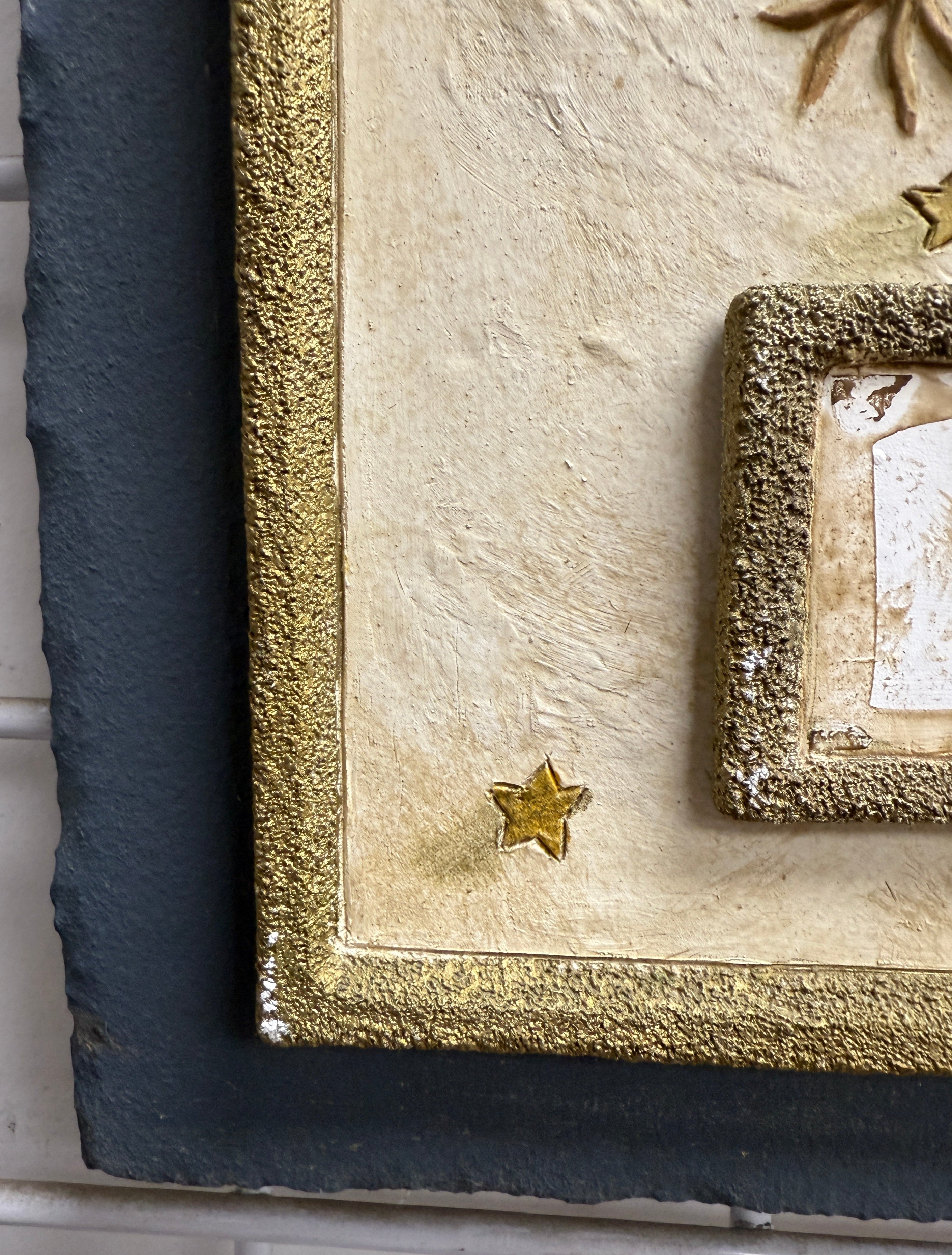 Close-up of a textured surface with a gold star and decorative elements.