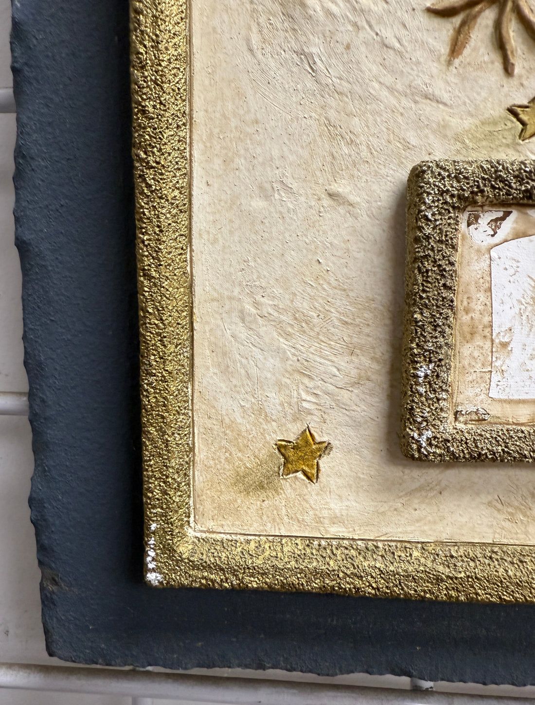 Close-up of a textured surface with a gold star and decorative elements.