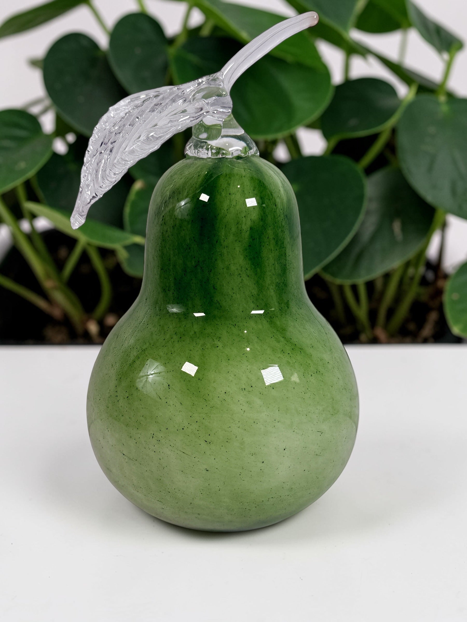 Vintage hand blown green art glass pear sculpture with clear leaf stem. Decorative Murano style glass fruit accent piece for kitchen or home décor.