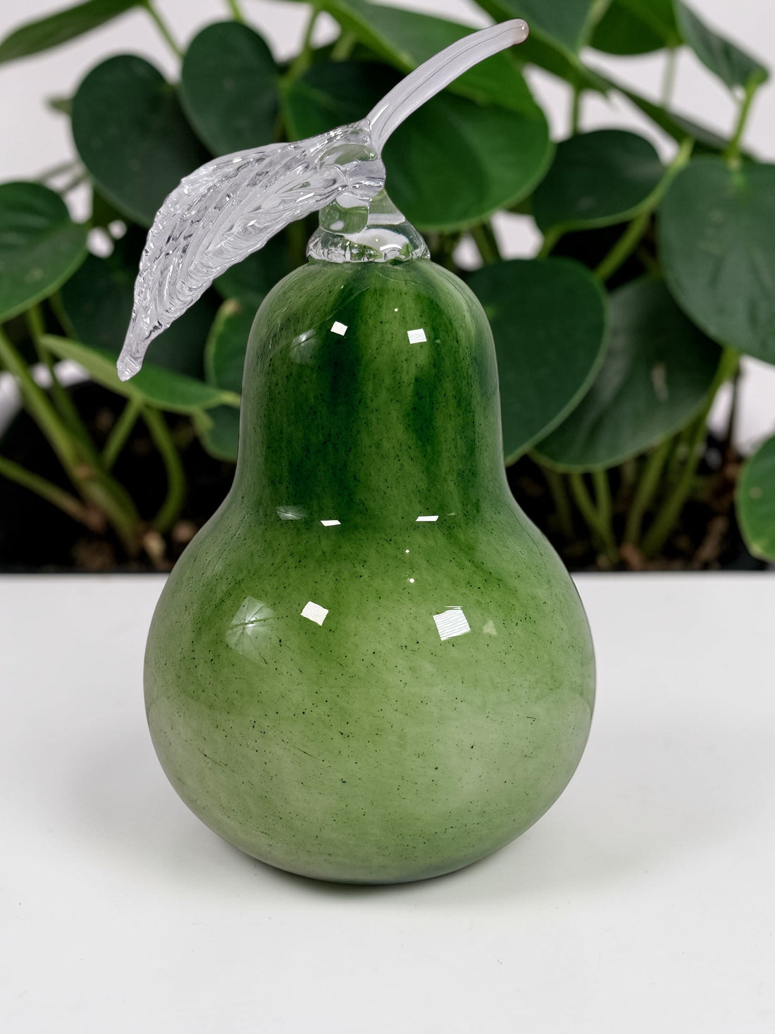Vintage hand blown green art glass pear sculpture with clear leaf stem. Decorative Murano style glass fruit accent piece for kitchen or home décor.