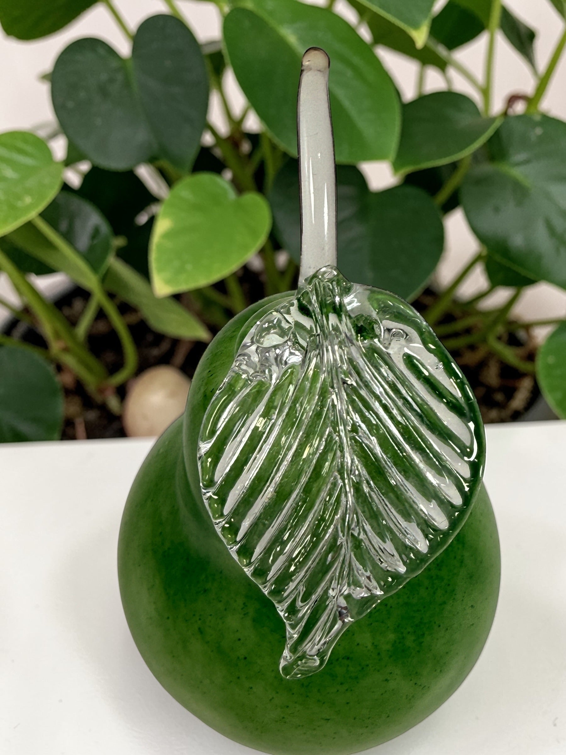 Vintage hand blown green art glass pear sculpture with clear leaf stem. Decorative Murano style glass fruit accent piece for kitchen or home décor.