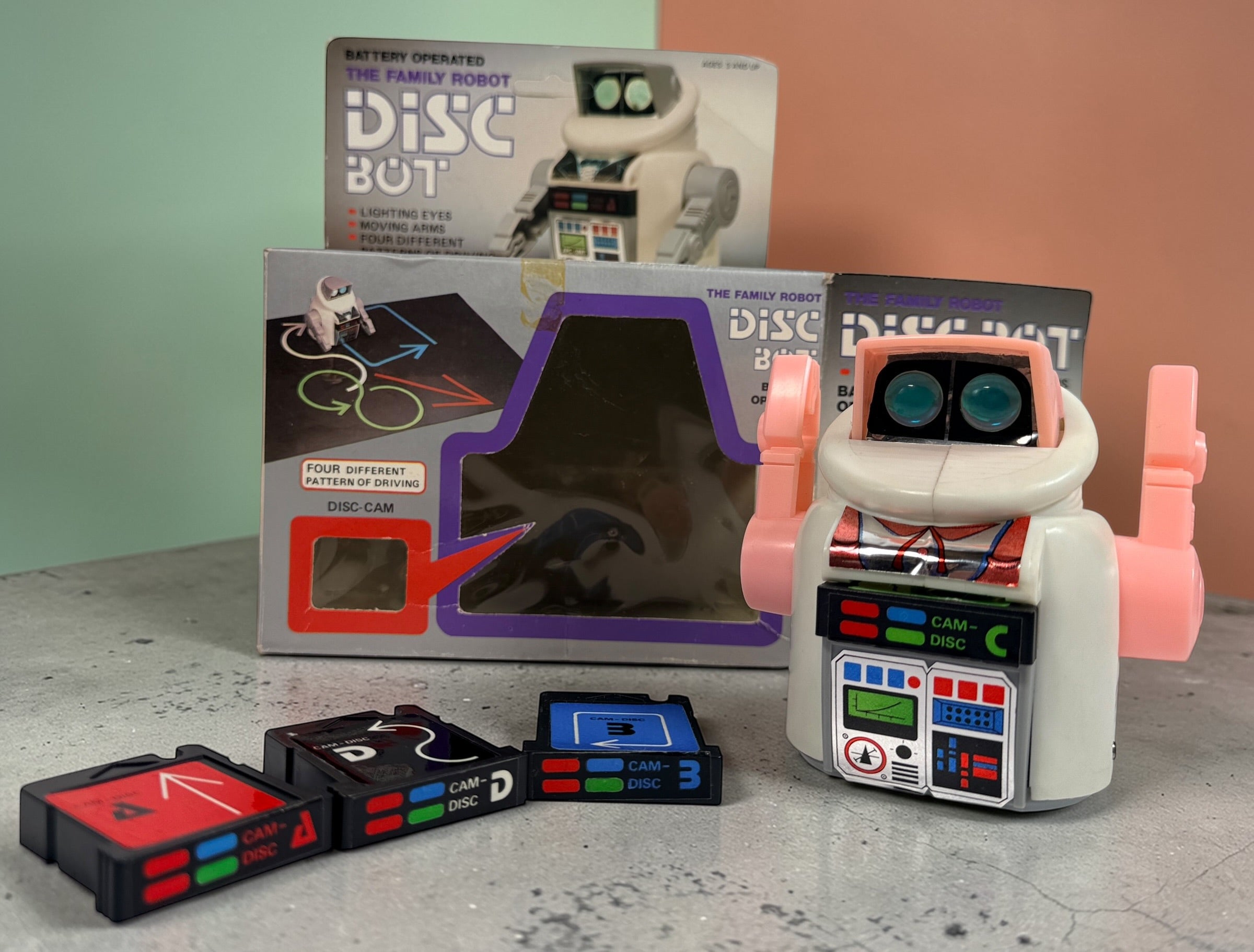 Vintage 1980s Disc Bot programmable toy robot with Disc Cam cartridges and original box. Battery operated retro robot toy made in Hong Kong.