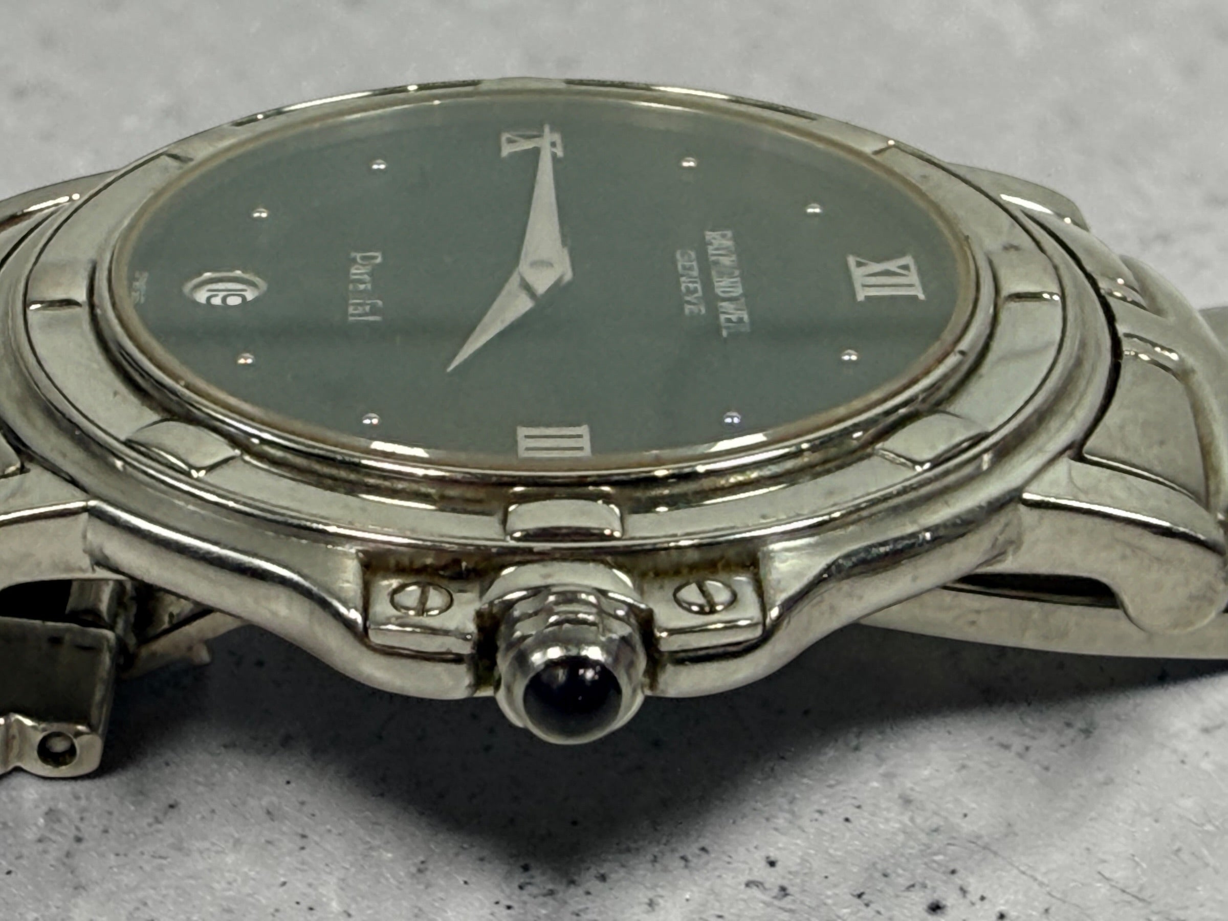 Raymond Weil Parsifal Swiss quartz watch with black dial, Roman numerals, and steel bracelet. Classic luxury design with date display, everyday wearable style.