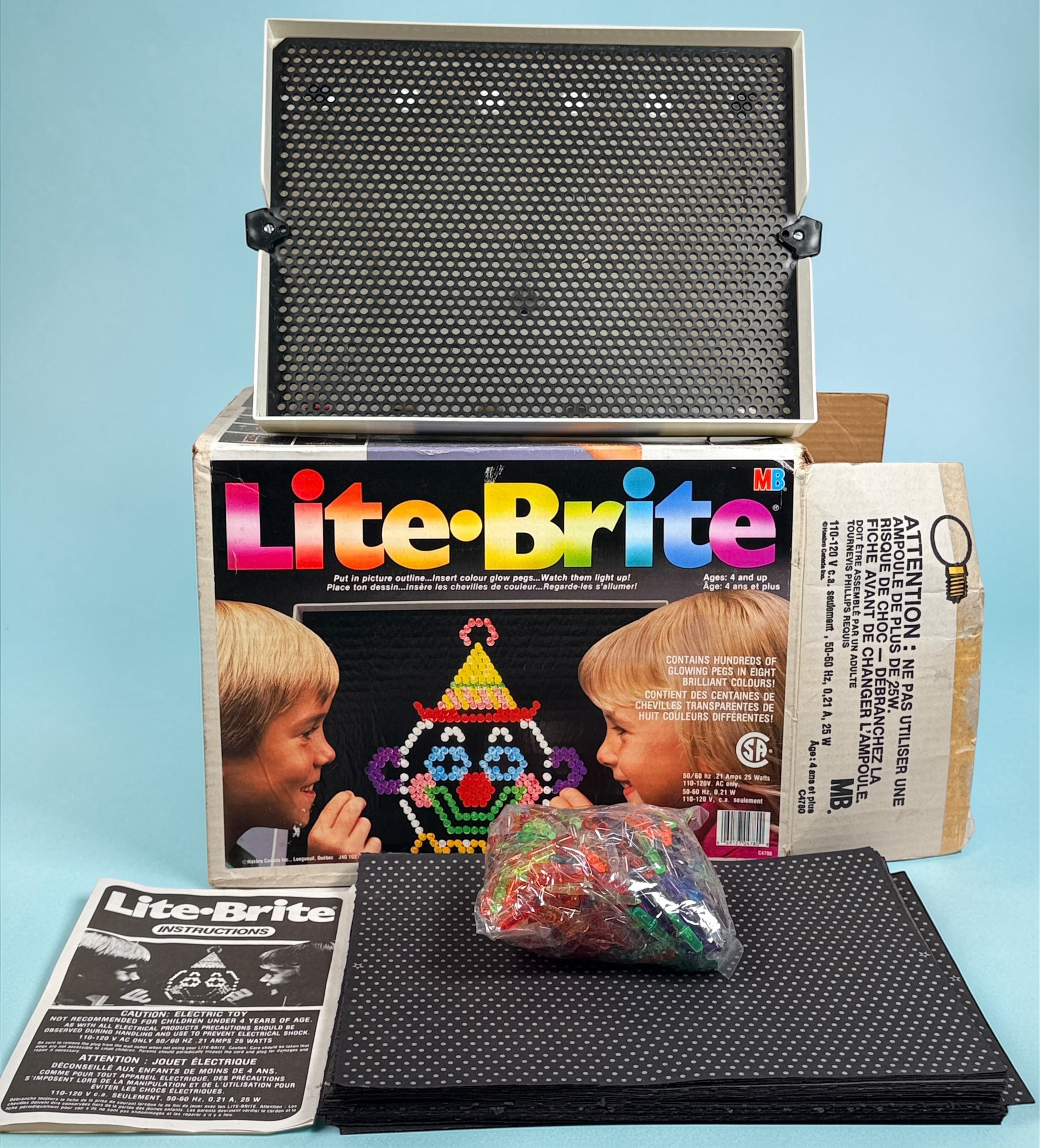 Vintage 1987 Lite-Brite Milton Bradley C4780 boxed set with pegs, 22 design sheets, and 20 blanks. Classic retro toy in very good condition.