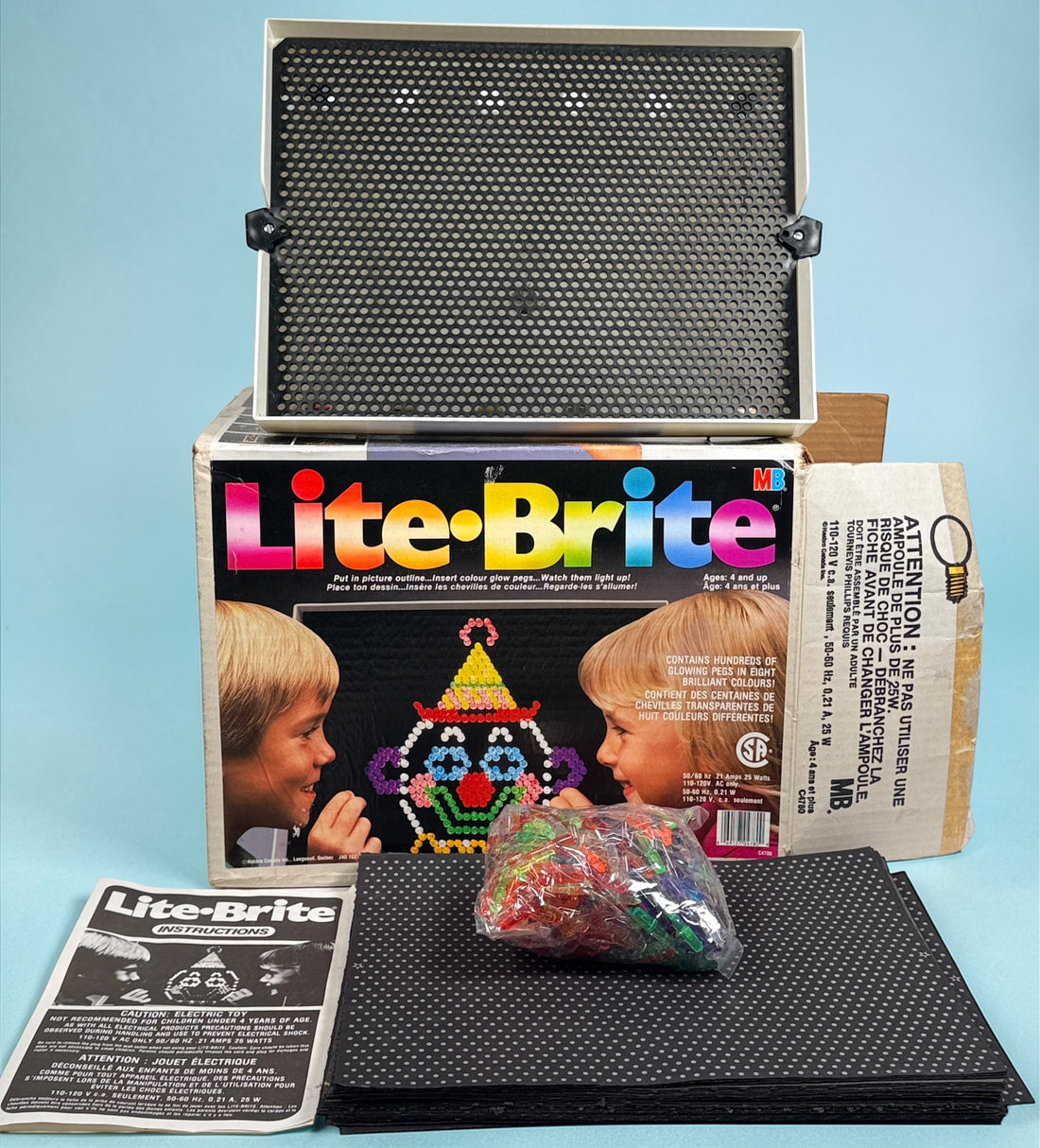 Vintage 1987 Lite-Brite Milton Bradley C4780 boxed set with pegs, 22 design sheets, and 20 blanks. Classic retro toy in very good condition.