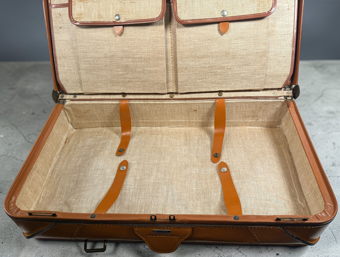 Vintage tan leather suitcase by Dionite Luggage. 1960s structured valise with brass hardware and interior compartments. Great for travel or decor.
