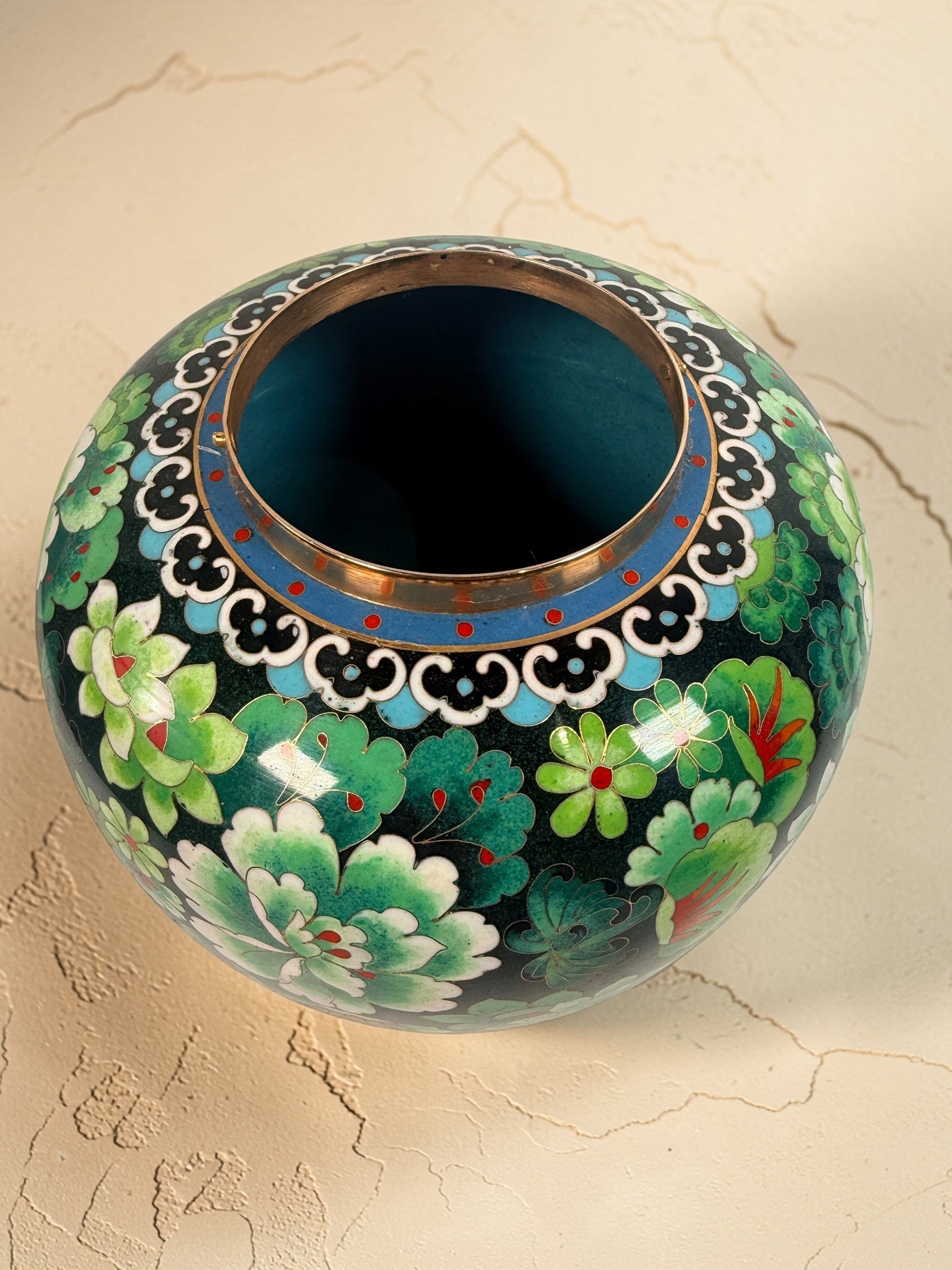 Vintage Japanese cloisonné enamel vase with floral design on black ground and turquoise interior. Decorative mid-century collectible in good condition.