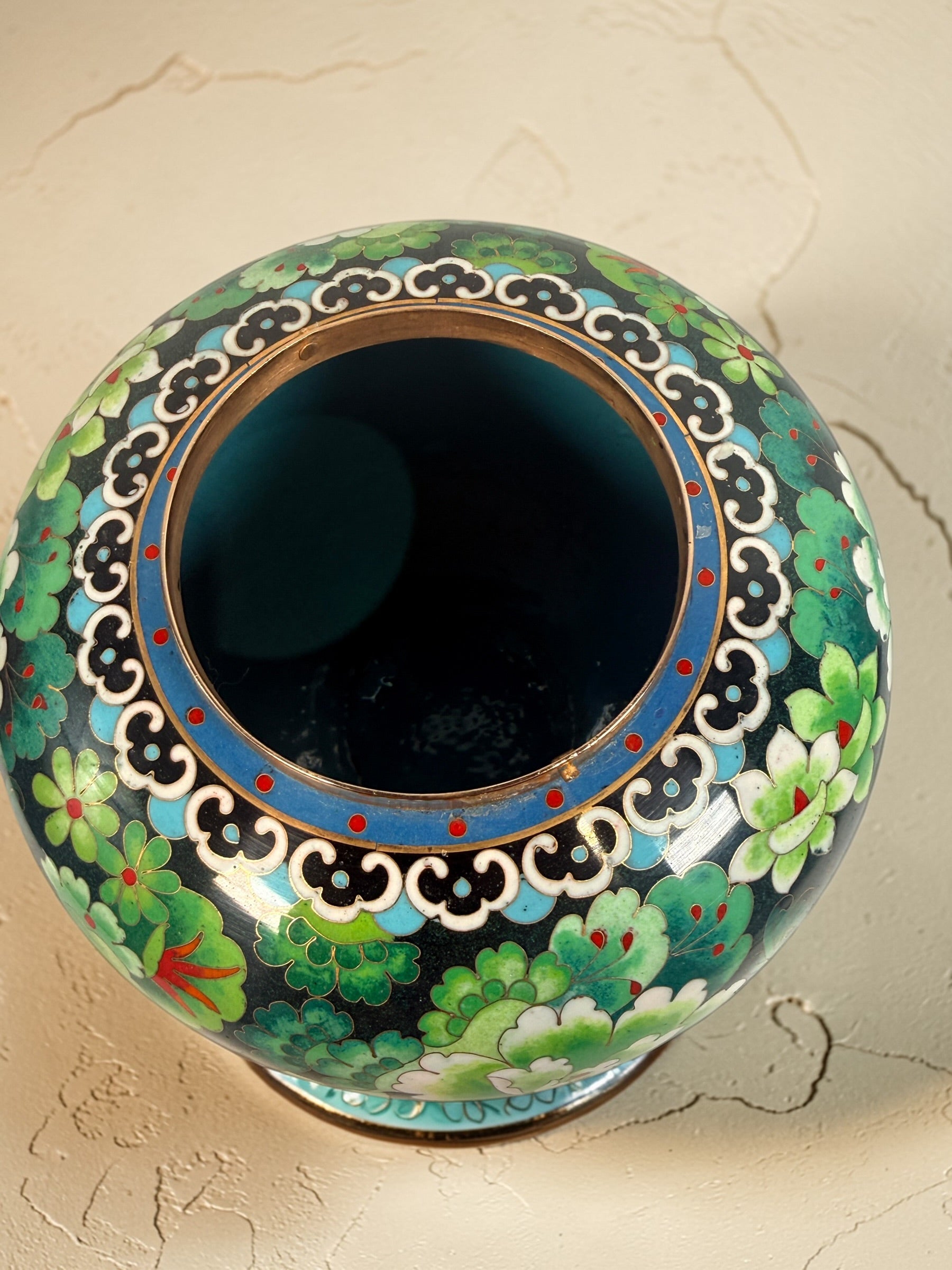 Vintage Japanese cloisonné enamel vase with floral design on black ground and turquoise interior. Decorative mid-century collectible in good condition.