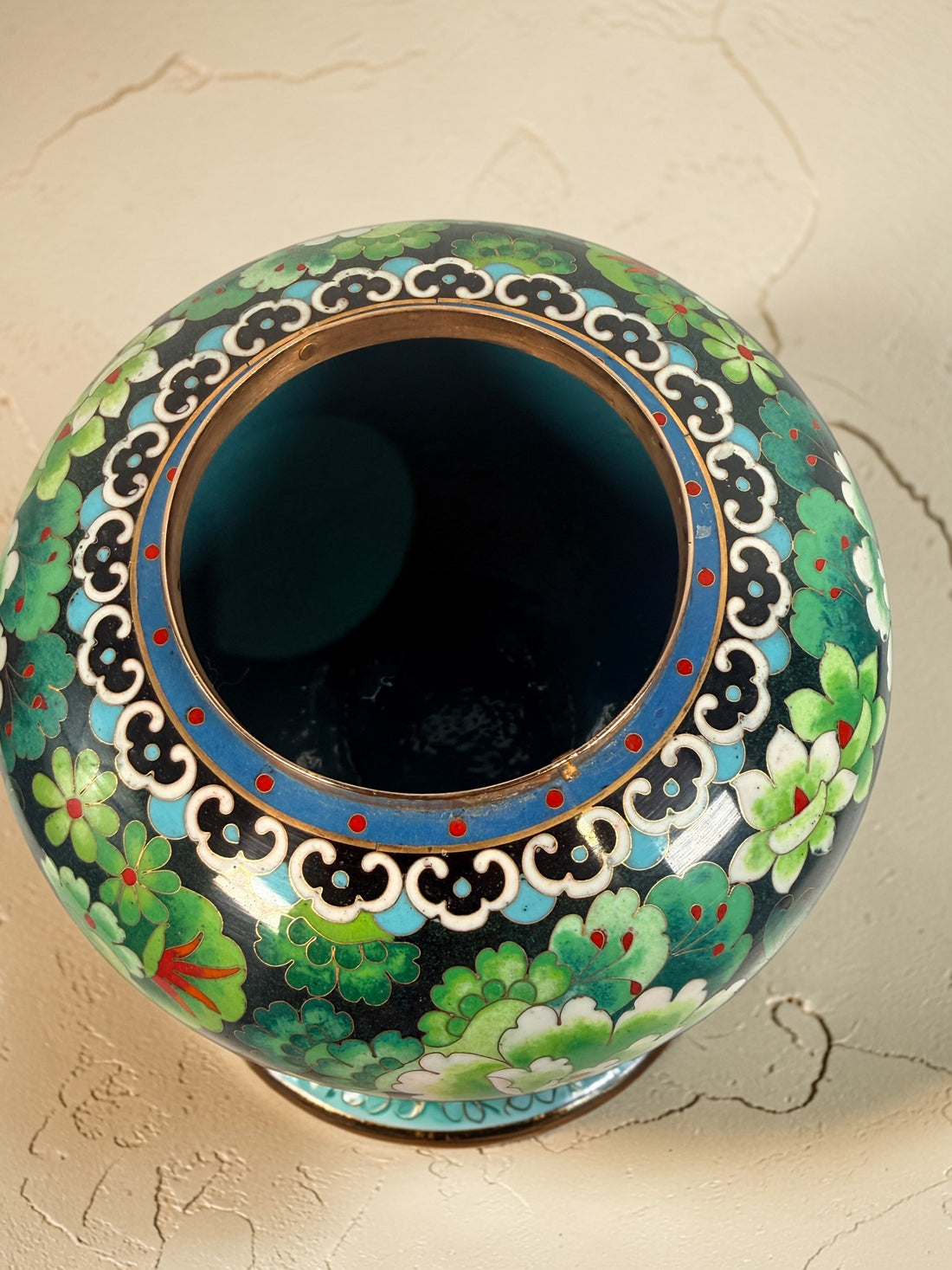 Vintage Japanese cloisonné enamel vase with floral design on black ground and turquoise interior. Decorative mid-century collectible in good condition.