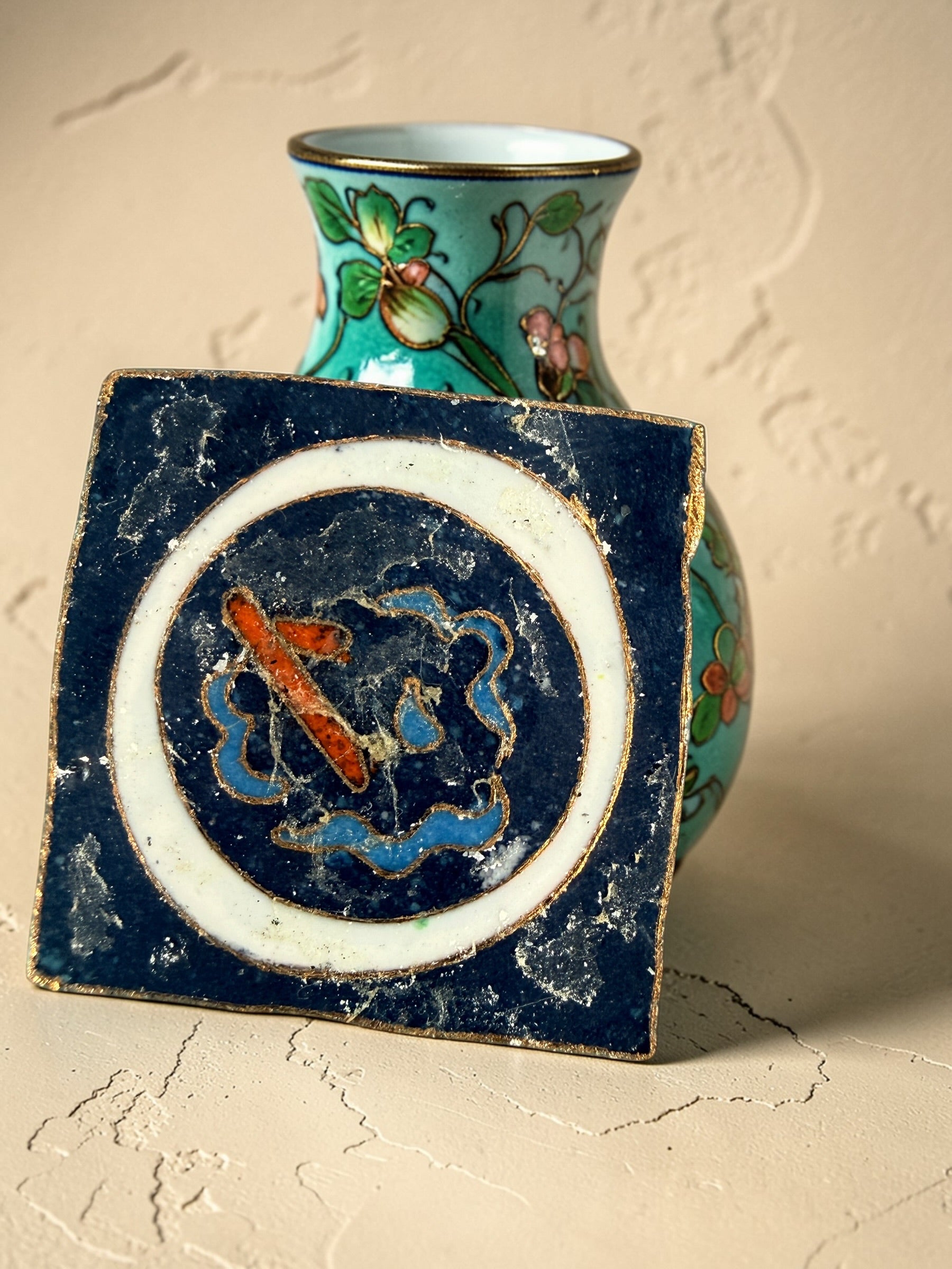 Vintage Japanese cloisonné enamel vase with floral design on black ground and turquoise interior. Decorative mid-century collectible in good condition.