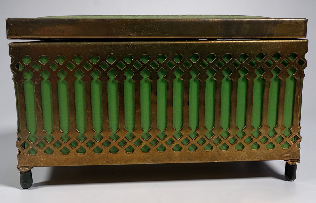 Vintage Mele Hollywood Regency jewelry box with brass filigree and green glass. Red velvet interior with compartments. Decorative mid-century piece.
