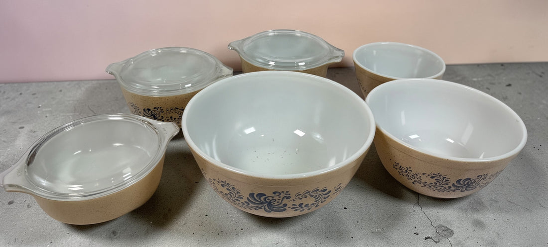 Vintage Pyrex Homestead blue floral mixing bowls and casserole dishes with lids. Classic farmhouse kitchenware set, durable glass, collectible and practical.