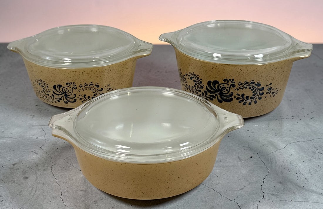 Vintage Pyrex Homestead blue floral mixing bowls and casserole dishes with lids. Classic farmhouse kitchenware set, durable glass, collectible and practical.