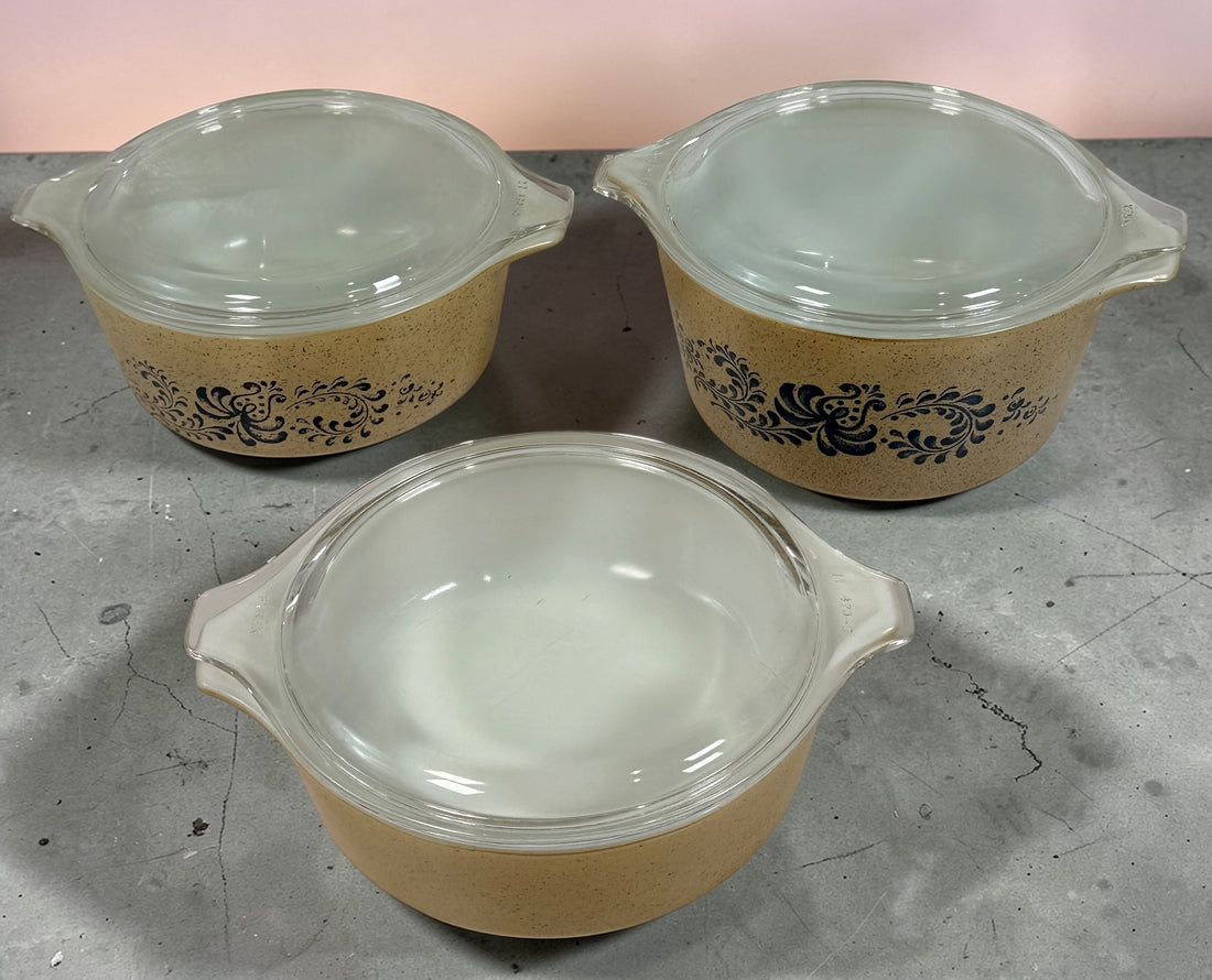 Vintage Pyrex Homestead blue floral mixing bowls and casserole dishes with lids. Classic farmhouse kitchenware set, durable glass, collectible and practical.