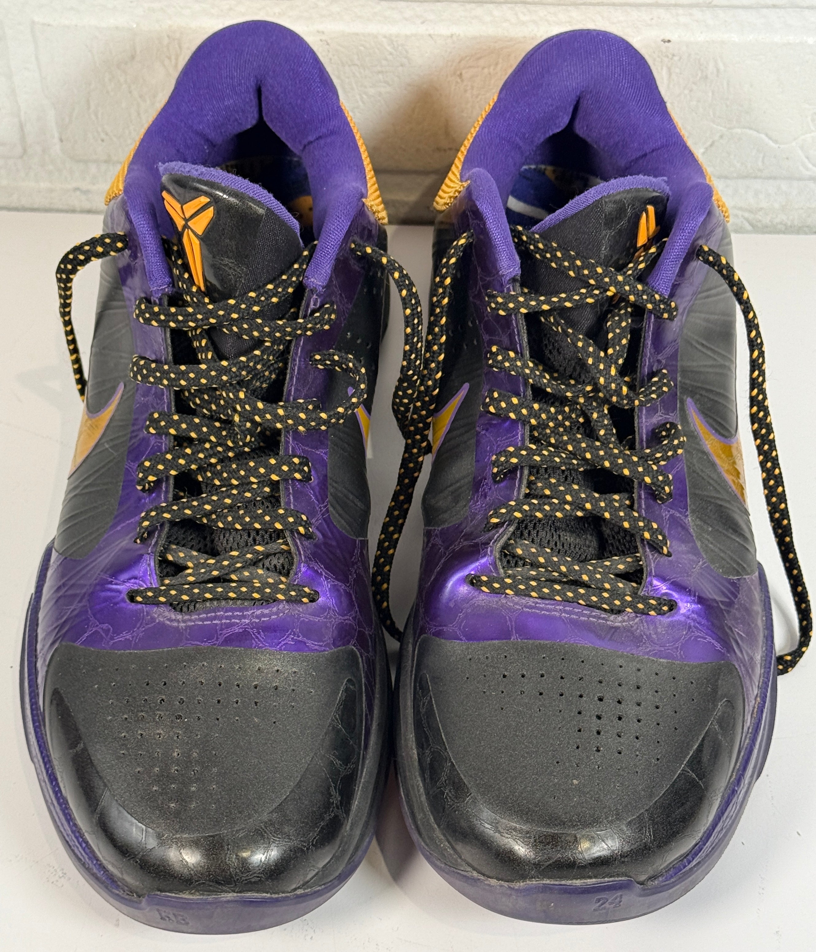 Nike Kobe 4 Lakers sneakers from 2009 in purple and gold. Classic low-top basketball shoes with Zoom cushioning, Kobe signature, and iconic Mamba design.