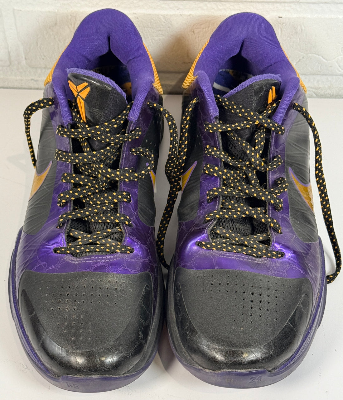 Nike Kobe 4 Lakers sneakers from 2009 in purple and gold. Classic low-top basketball shoes with Zoom cushioning, Kobe signature, and iconic Mamba design.