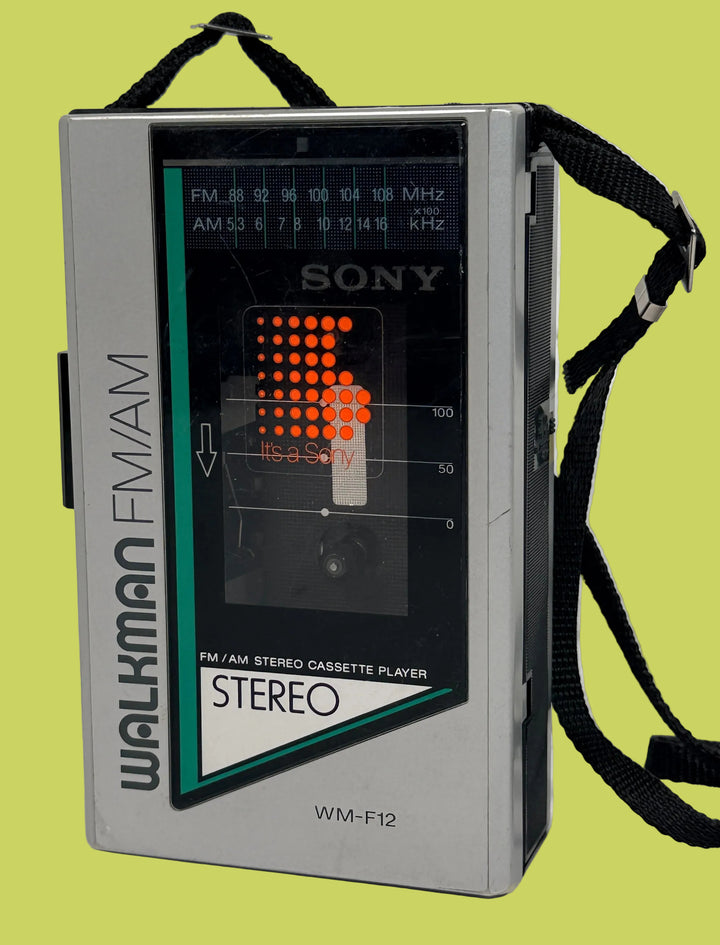 Vintage Sony Walkman WM-F12 with a strap on a light background