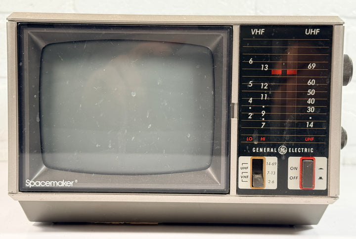 Vintage GE Spacemaker portable TV from 1986, compact black &amp; white CRT with VHF/UHF tuning. Retro electronics piece perfect for display or collection.