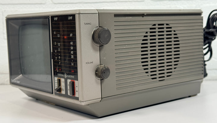 Vintage GE Spacemaker portable TV from 1986, compact black &amp; white CRT with VHF/UHF tuning. Retro electronics piece perfect for display or collection.