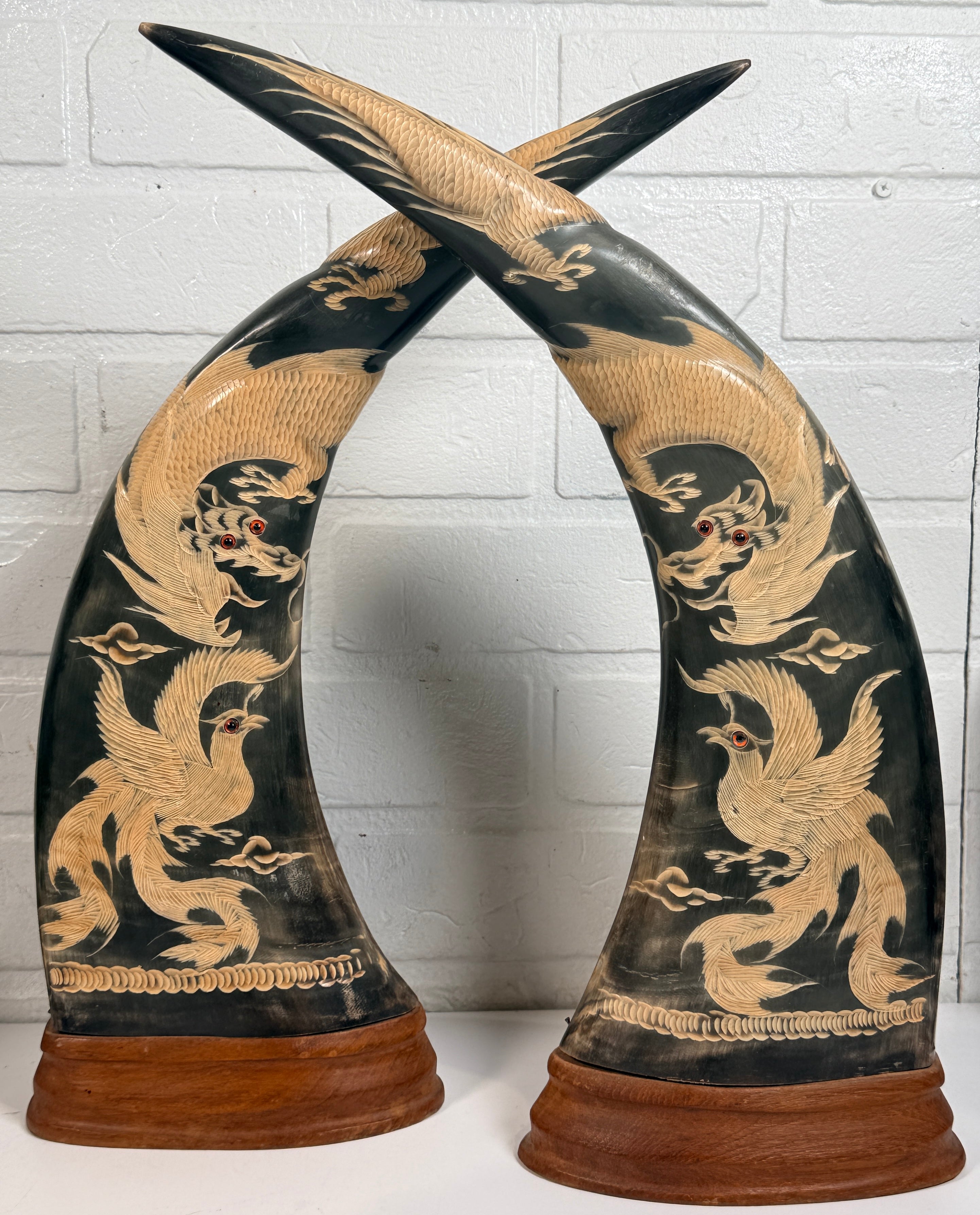 Vintage pair buffalo horn dragon phoenix statues on hardwood bases. Hand carved Asian décor sculptures with dramatic natural horn shape and collectible appeal.