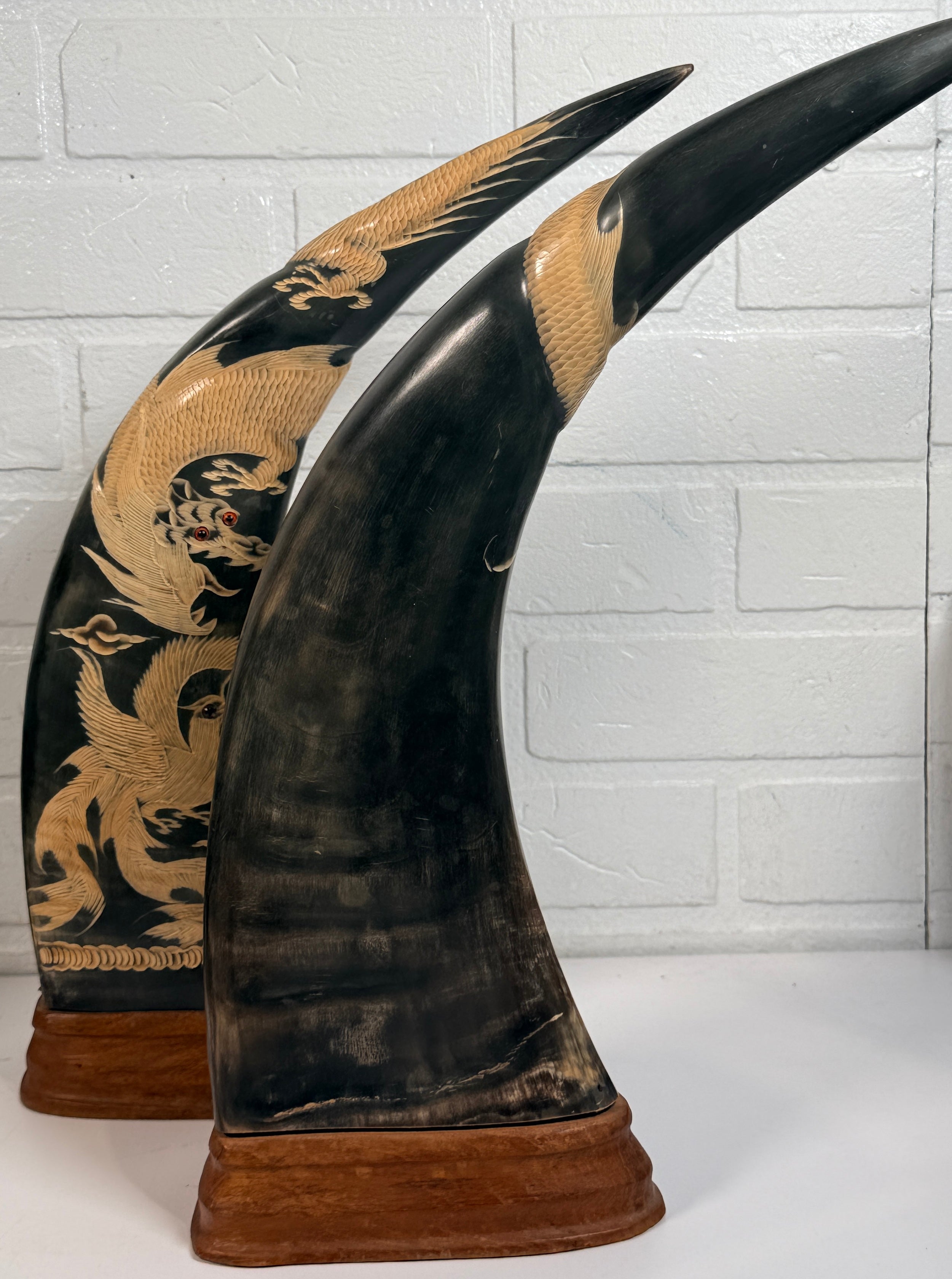 Vintage pair buffalo horn dragon phoenix statues on hardwood bases. Hand carved Asian décor sculptures with dramatic natural horn shape and collectible appeal.