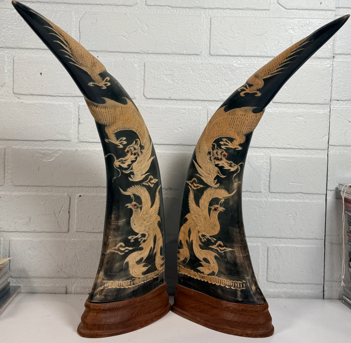 Vintage pair buffalo horn dragon phoenix statues on hardwood bases. Hand carved Asian décor sculptures with dramatic natural horn shape and collectible appeal.