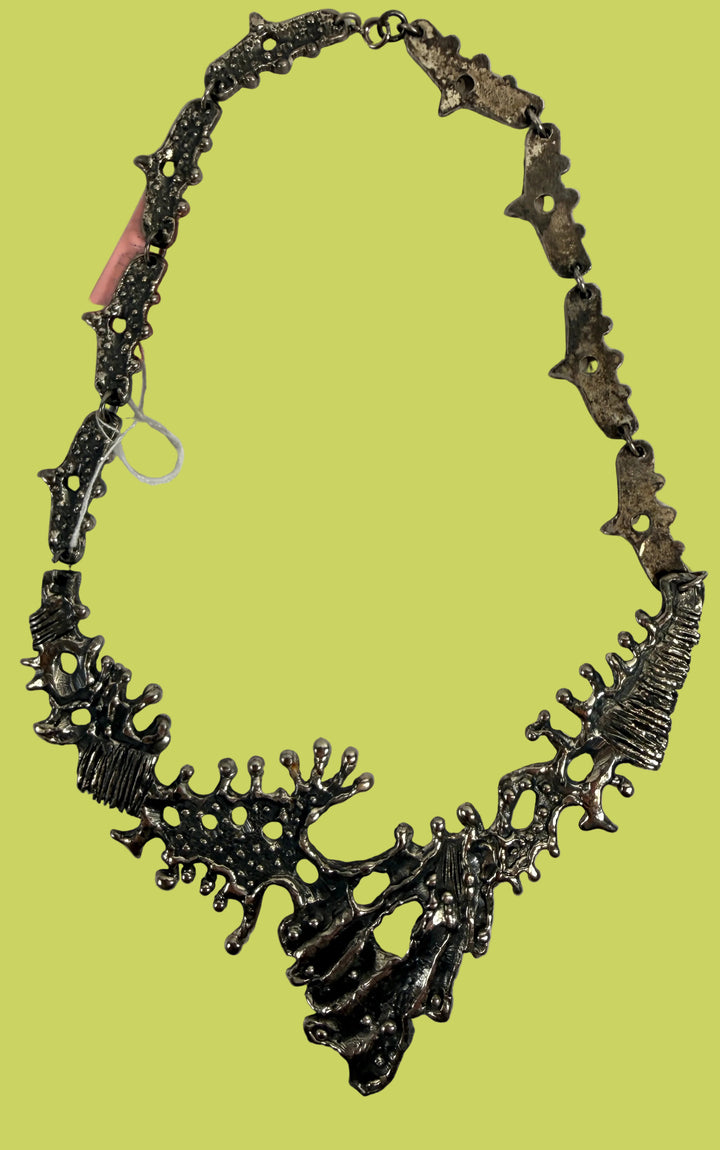 Vintage brutalist pewter necklace with sculptural modernist bib design. Unique 1970s statement jewelry in silver tone wearable art style.