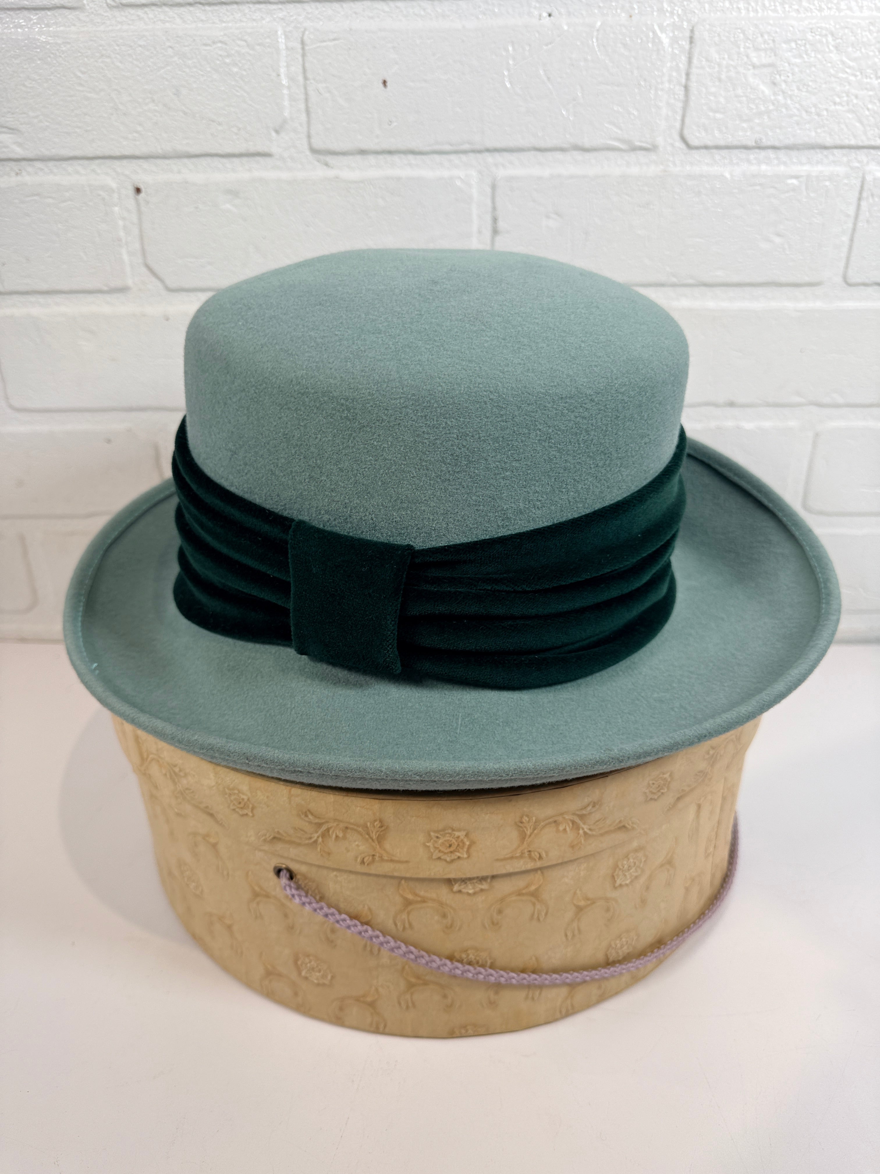 Vintage Alexon wool felt hat in mint green with black velvet trim, made in Great Britain. Includes original hat box. Elegant retro formal fashion piece.