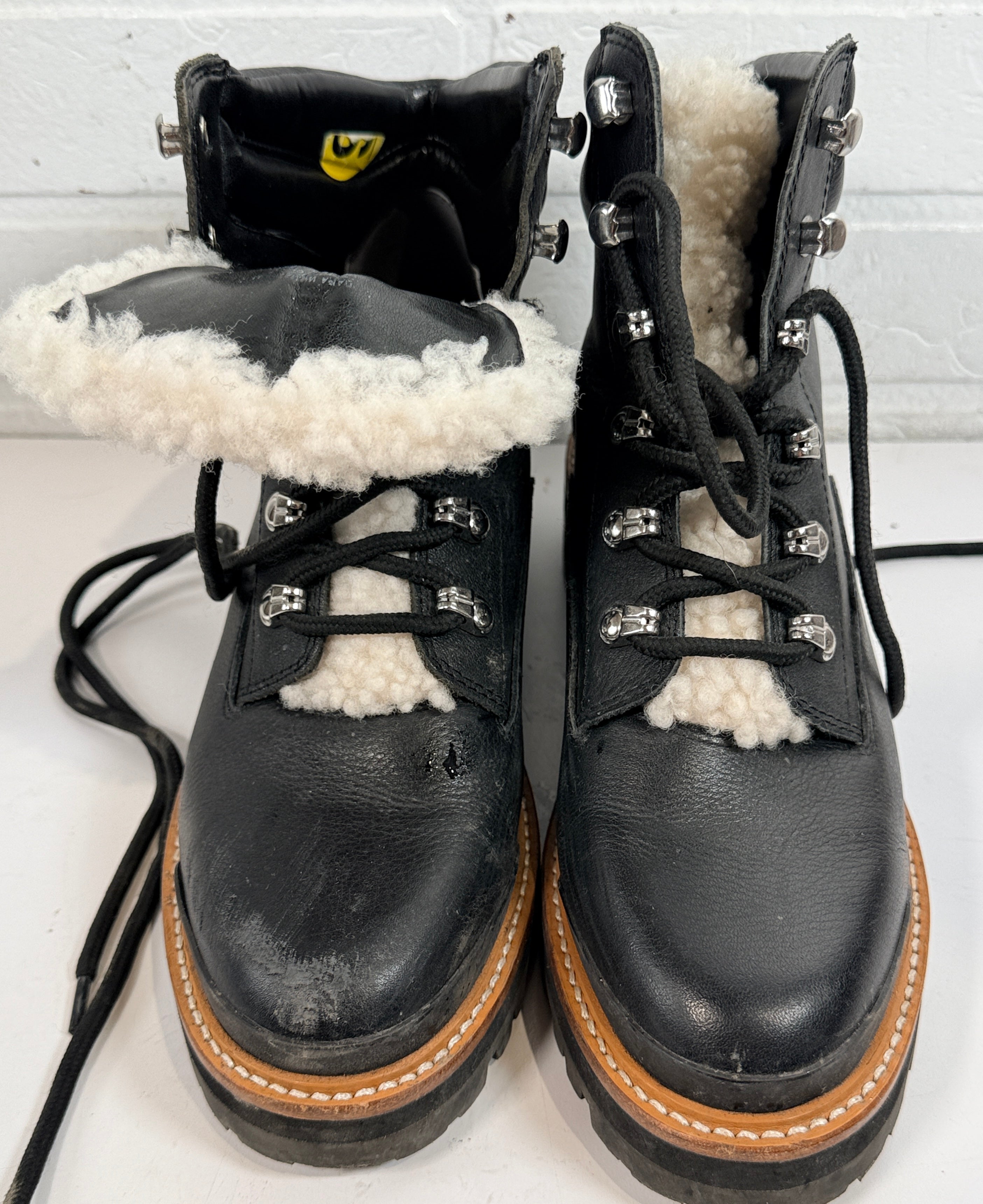 Marc Fisher shearling lined black leather hiking boots size 9M. Rugged winter lace-up ankle boots with lug soles and warm lining, pre-owned condition.
