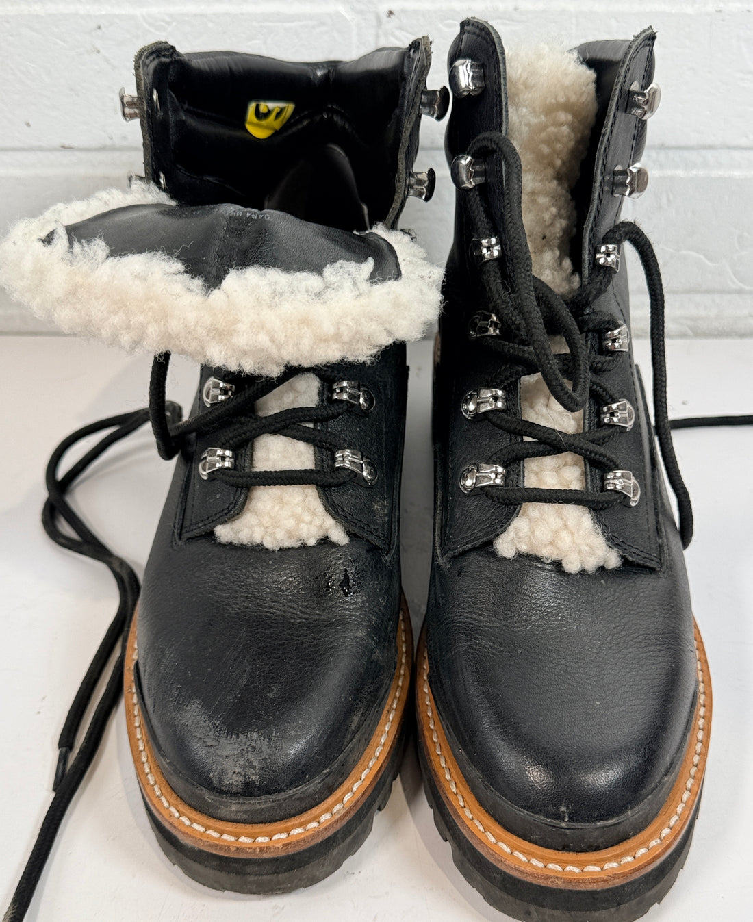 Marc Fisher shearling lined black leather hiking boots size 9M. Rugged winter lace-up ankle boots with lug soles and warm lining, pre-owned condition.