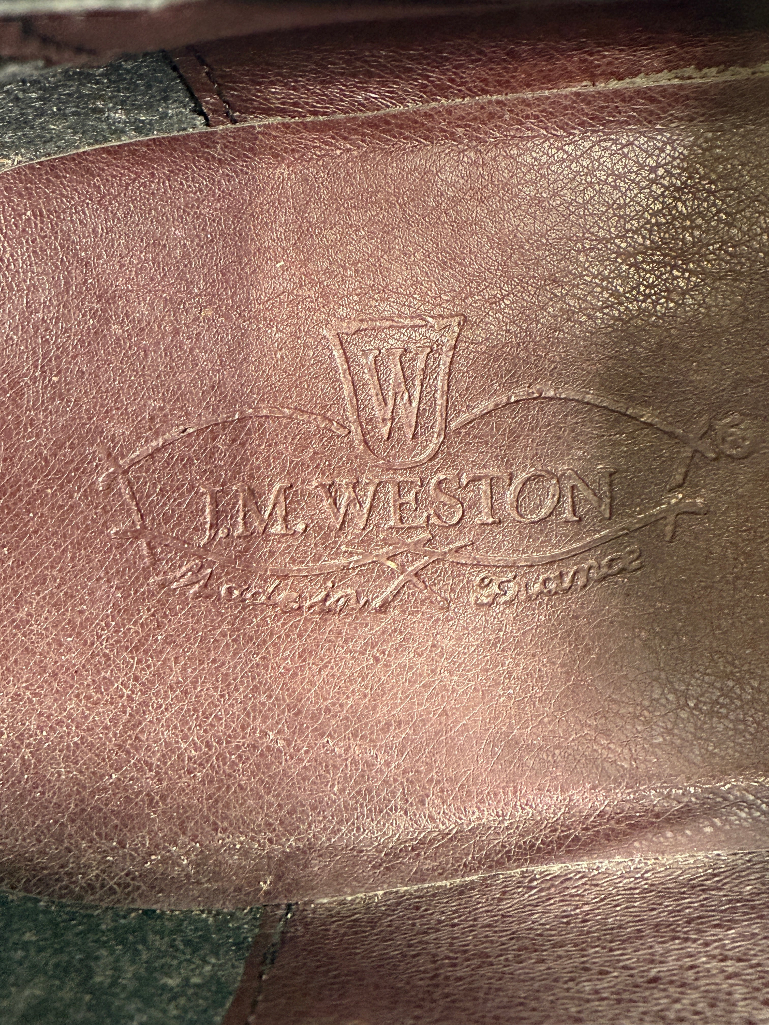 Close-up of a brown leather surface with 'McWeston' branding.