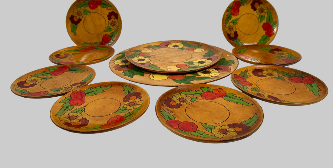 Set of decorative plates with floral and fruit patterns on a white surface.