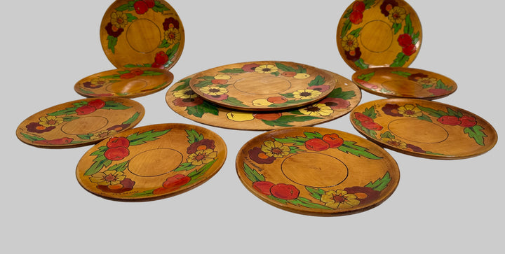 Set of decorative plates with floral and fruit patterns on a white surface.