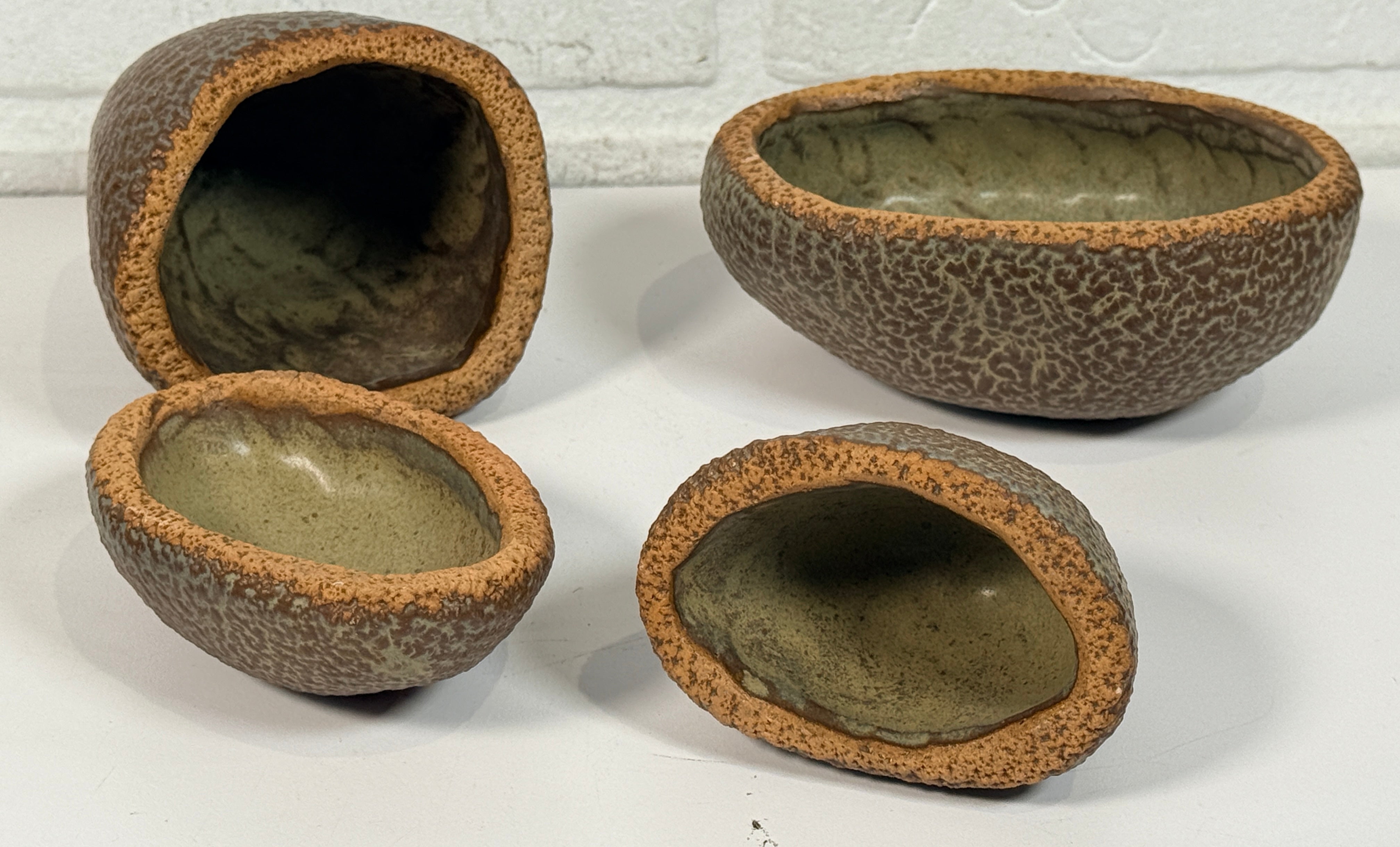 Vintage sculptural nesting pebble vessels set of 4 studio pottery ceramic organic modern brutalist decor art objects collectible display pieces.